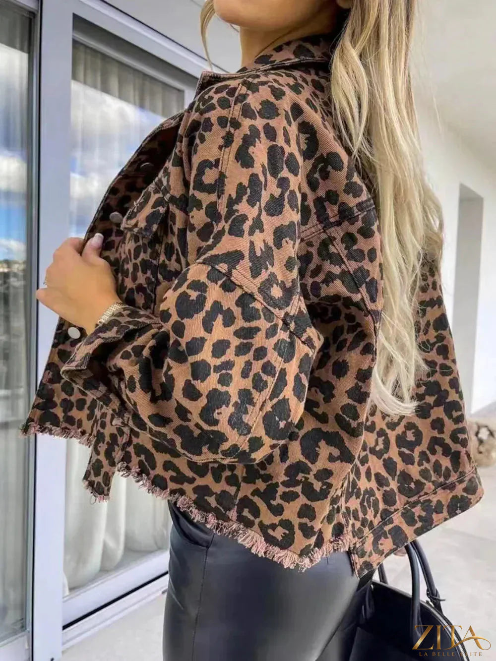 Raw hem leopard print denim jacket with collared neck from Trendsi, featuring classic blue denim and leopard pattern details.