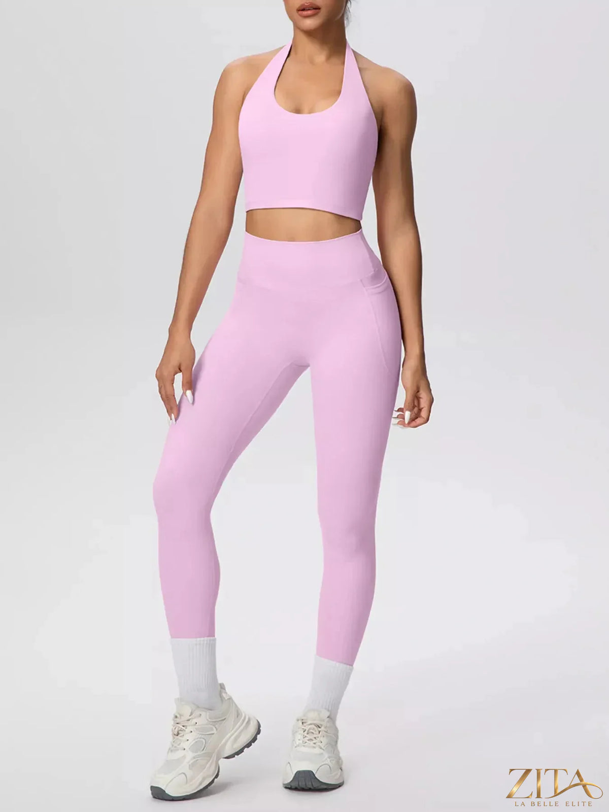 Zita La Belle Elite halter neck crop top and high-waisted leggings active set, shown in black, on a model with a gym background.