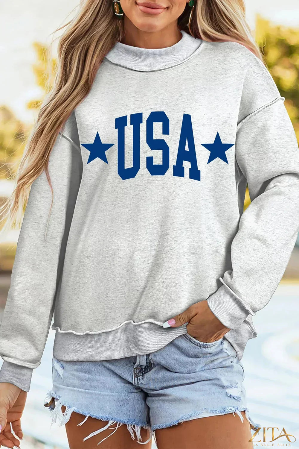 Zita La Belle Elite mock neck sweatshirt with USA slogan graphic, featuring a comfortable fit and bold patriotic design.