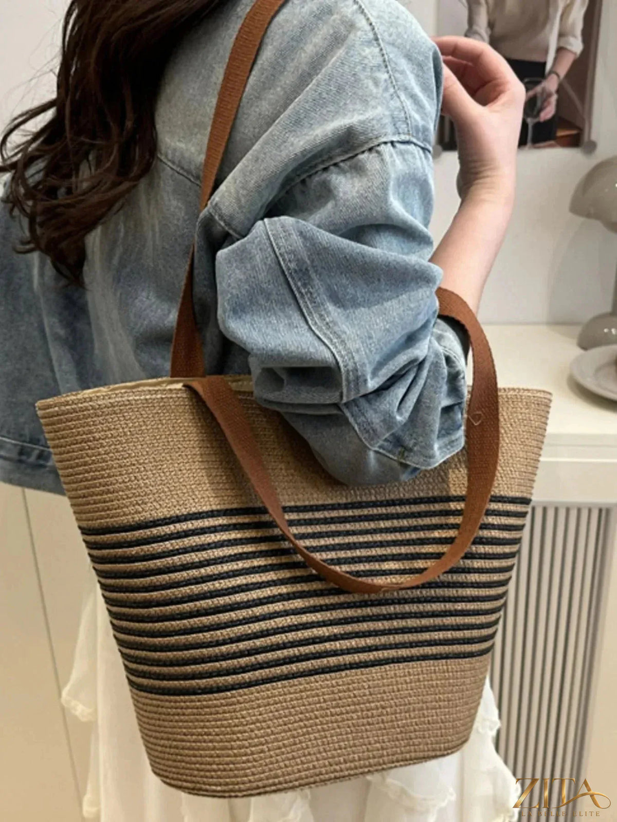 Striped woven tote bag by Zita La Belle Elite with blue, white, and beige stripes, featuring sturdy handles and spacious interior.