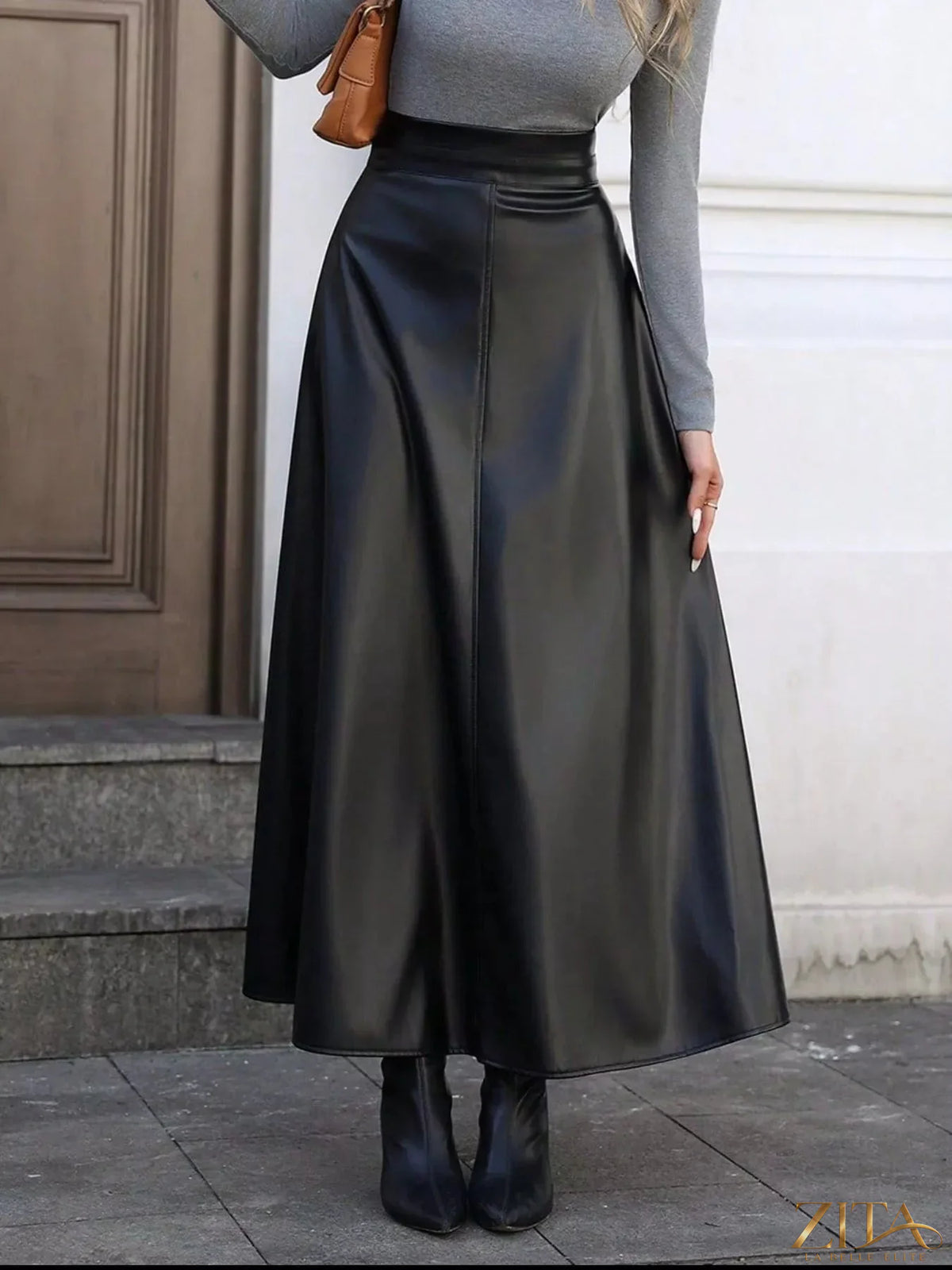 Leather A-Line midi skirt by Trendsi, showcasing a sleek, black leather fabric with a high waist and flowing midi length.