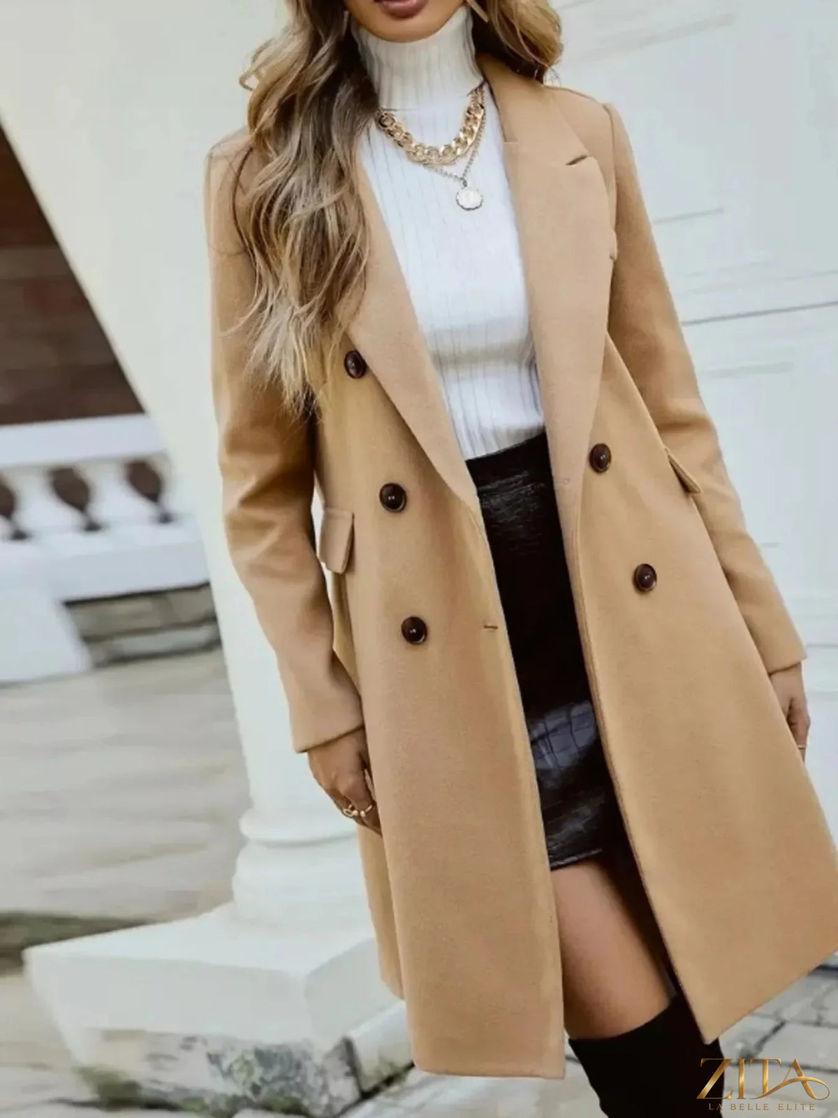 Zita La Belle Elite double-breasted longline coat in neutral fabric, featuring wide lapels and tailored fit, displayed on a hanger.