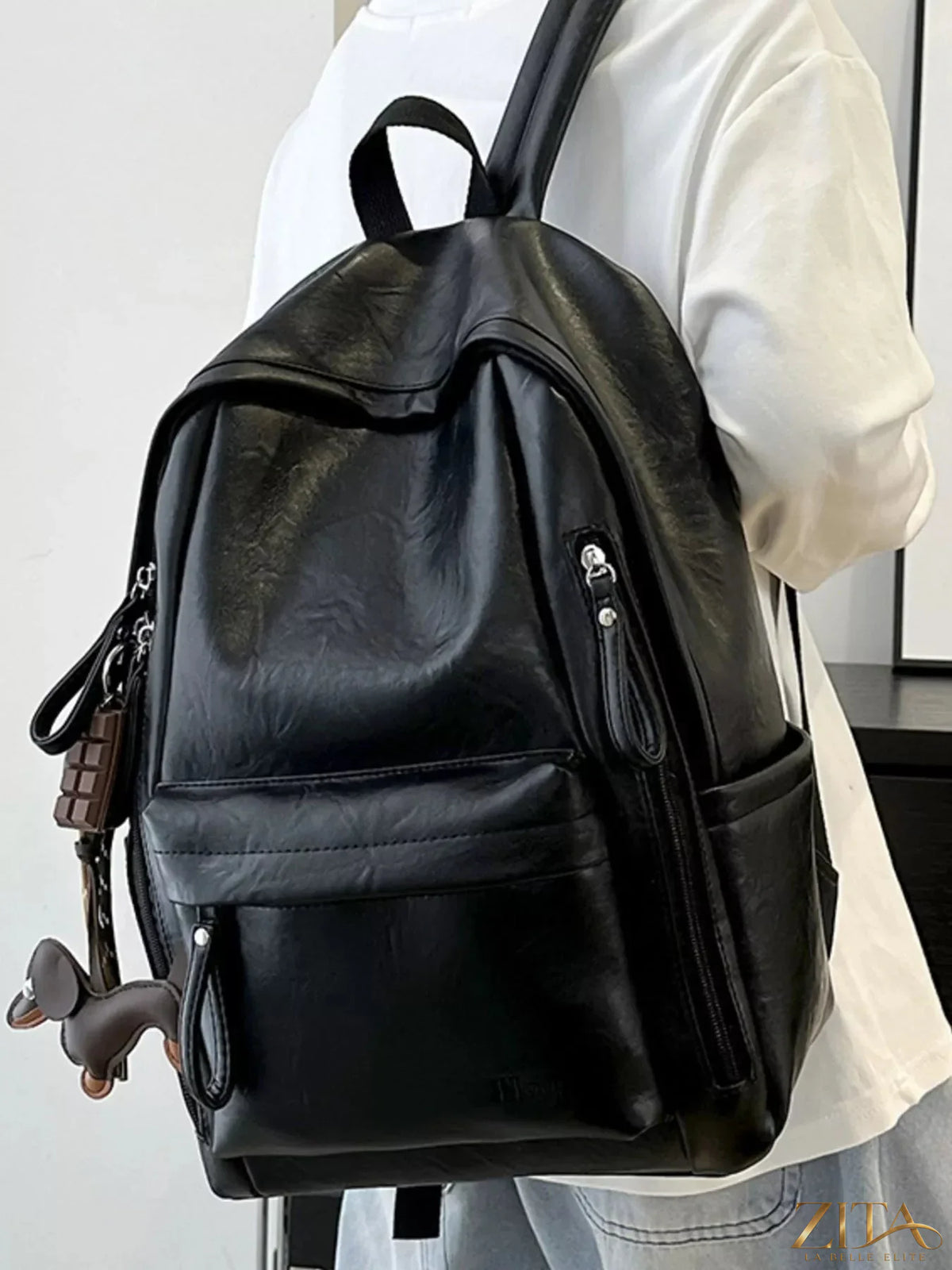 Leather texture backpack bag by Trendsi with adjustable straps and multiple compartments, showcasing a stylish, durable design.