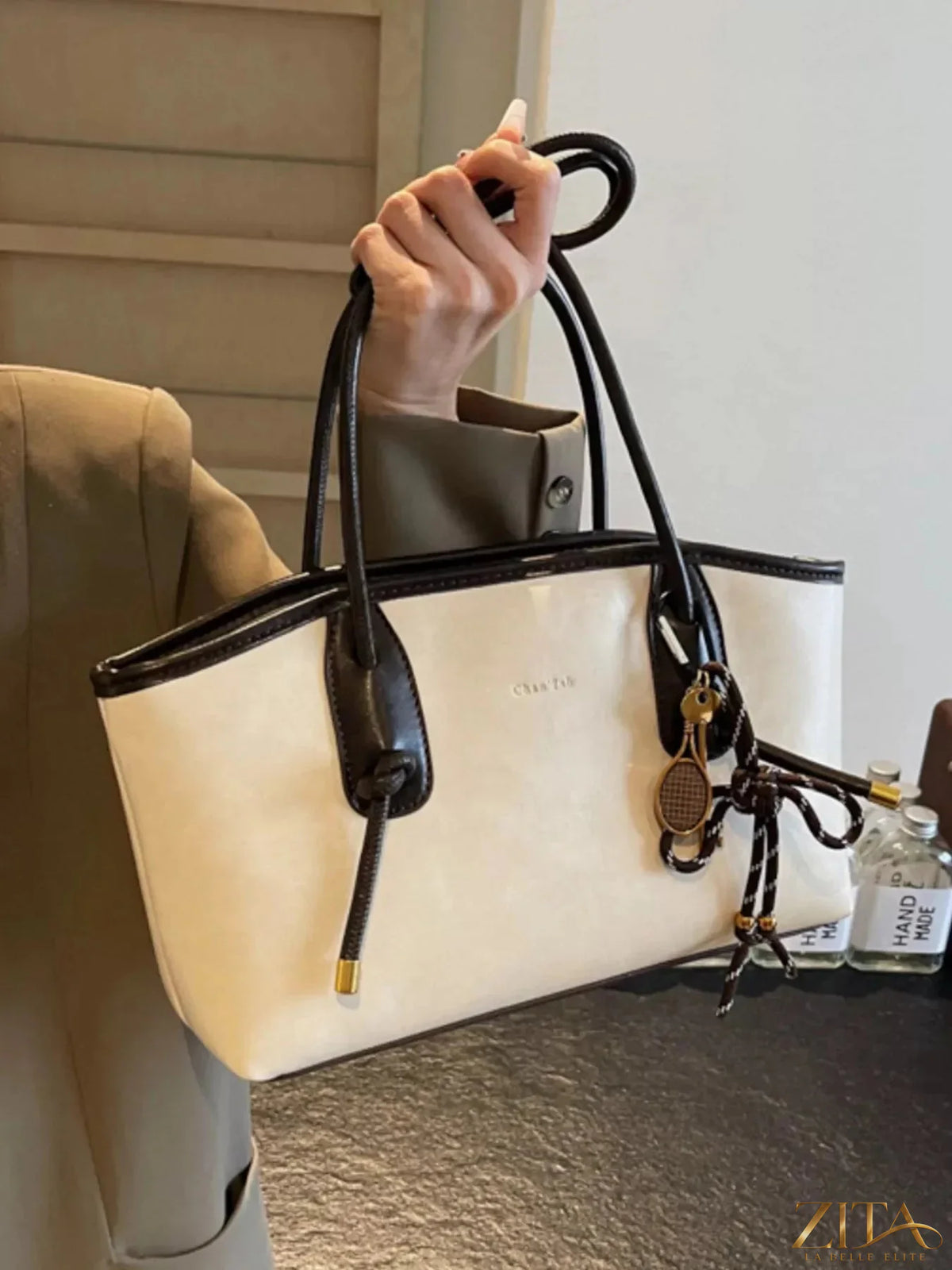 Two-tone shoulder bag by Zita La Belle Elite with sleek design and gold hardware, shown in a stylish close-up image.