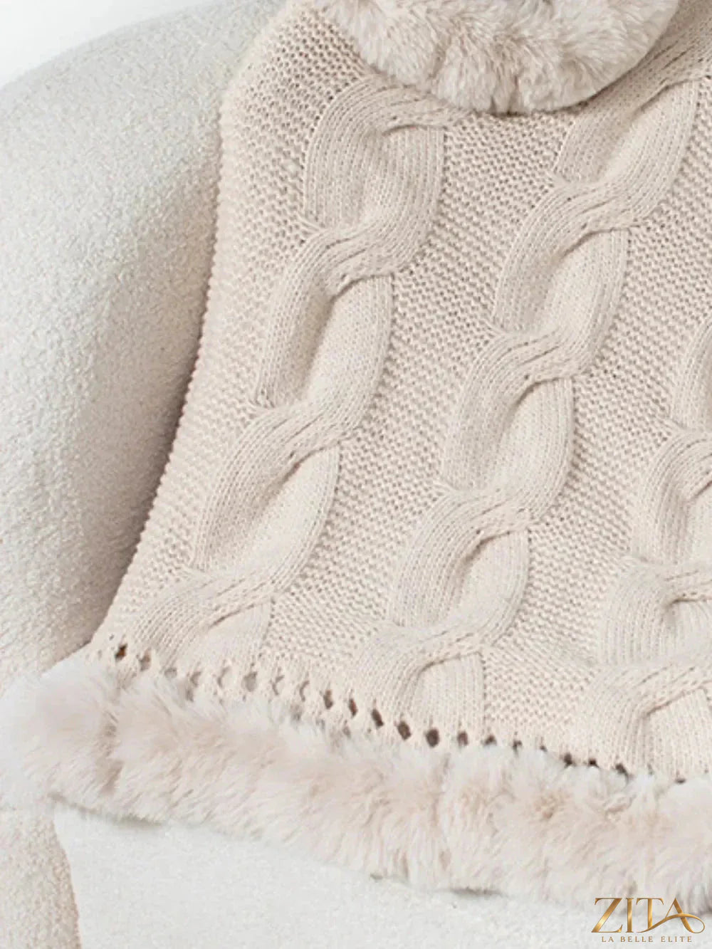 Fuzzy hem cable-knit poncho by Trendsi featuring a cozy, textured knit with a fuzzy hem detail and relaxed fit.