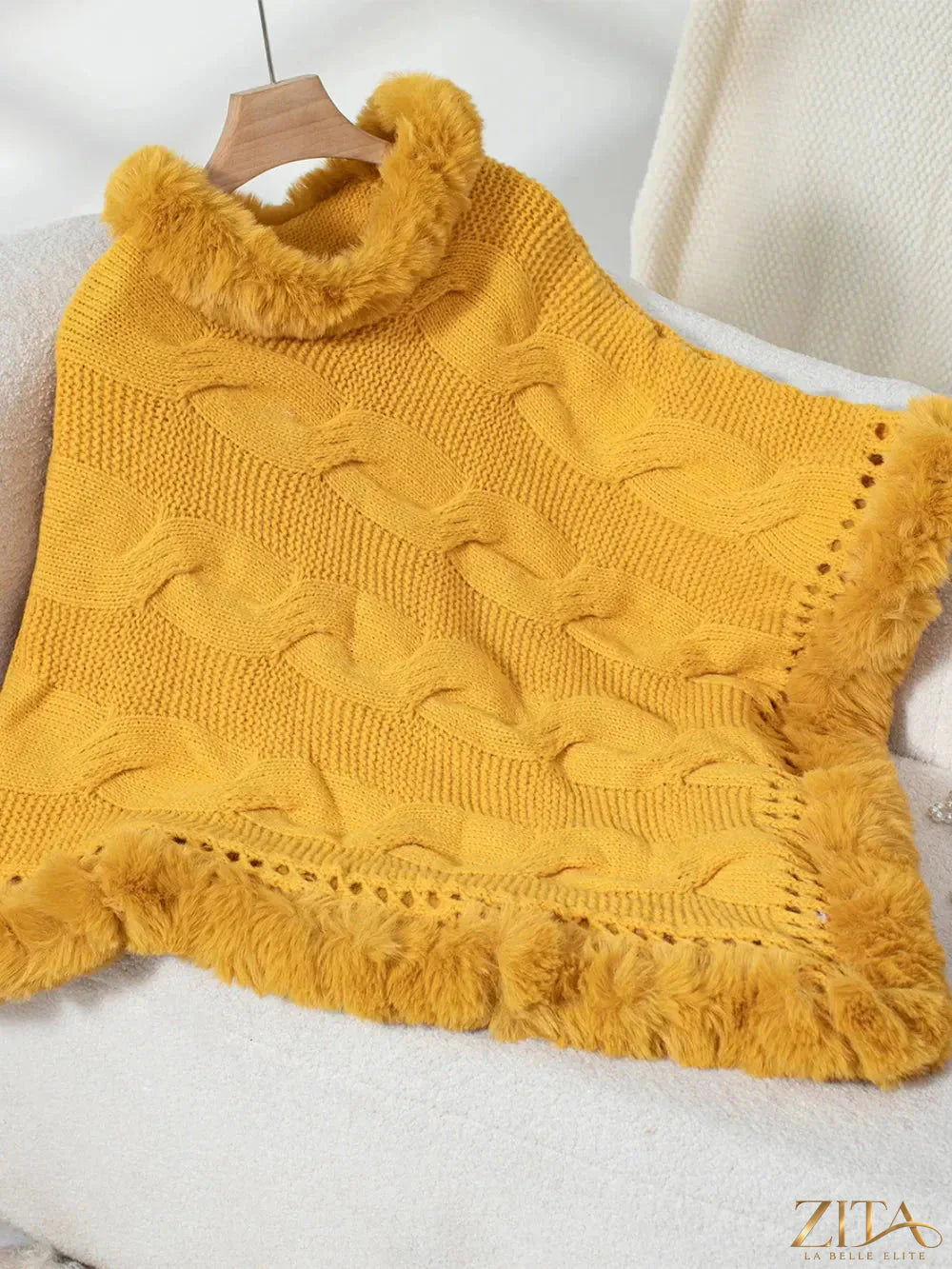 Fuzzy hem cable-knit poncho by Trendsi featuring a cozy, textured design with a relaxed fit and stylish cable-knit pattern.