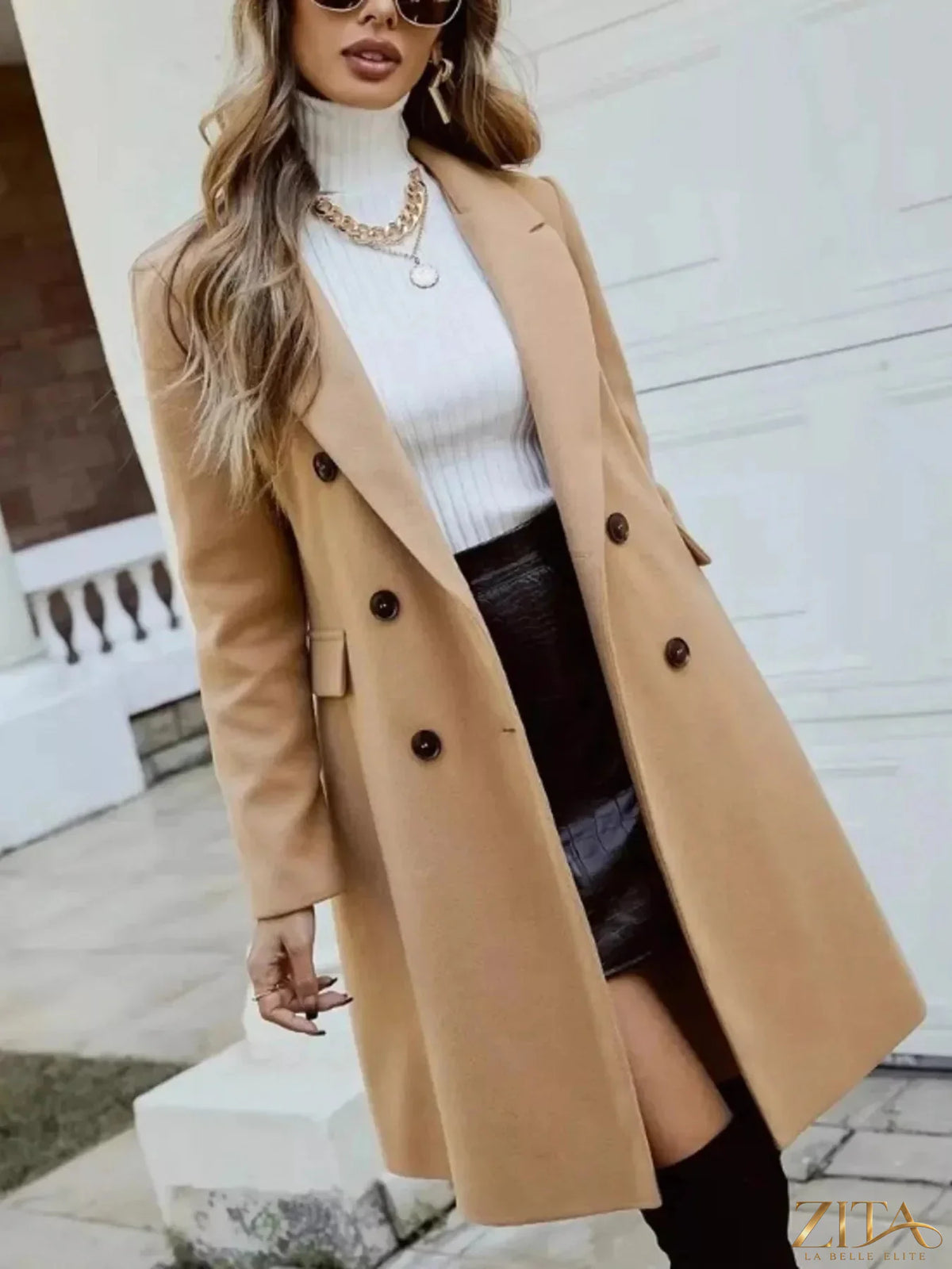 Zita La Belle Elite double-breasted longline coat displayed on a hanger, featuring a tailored fit and classic design in neutral fabric.
