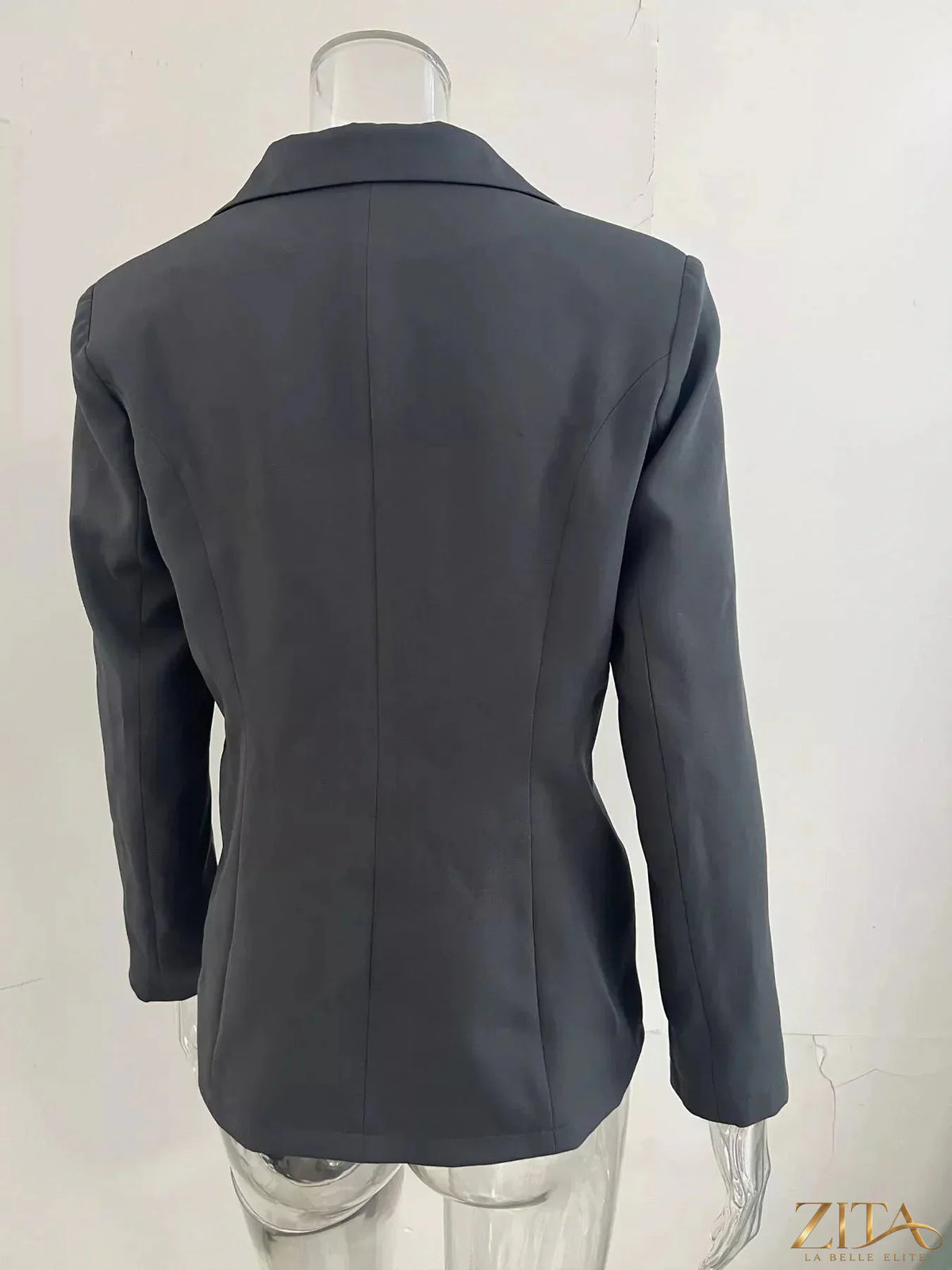 Slim-fit casual blazer by Trendsi featuring a single button, tailored fit, and classic lapel, shown in a neutral fabric.