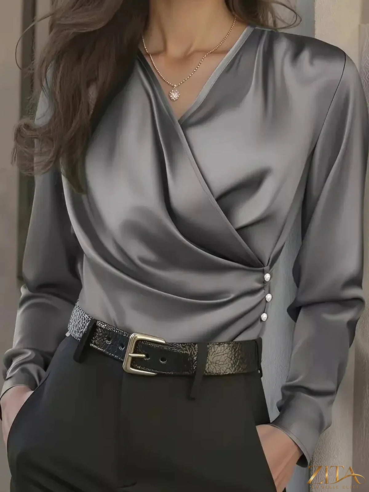 Zita La Belle Elite satin surplice long sleeve blouse with elegant draping and a smooth, shiny finish, displayed on a hanger.