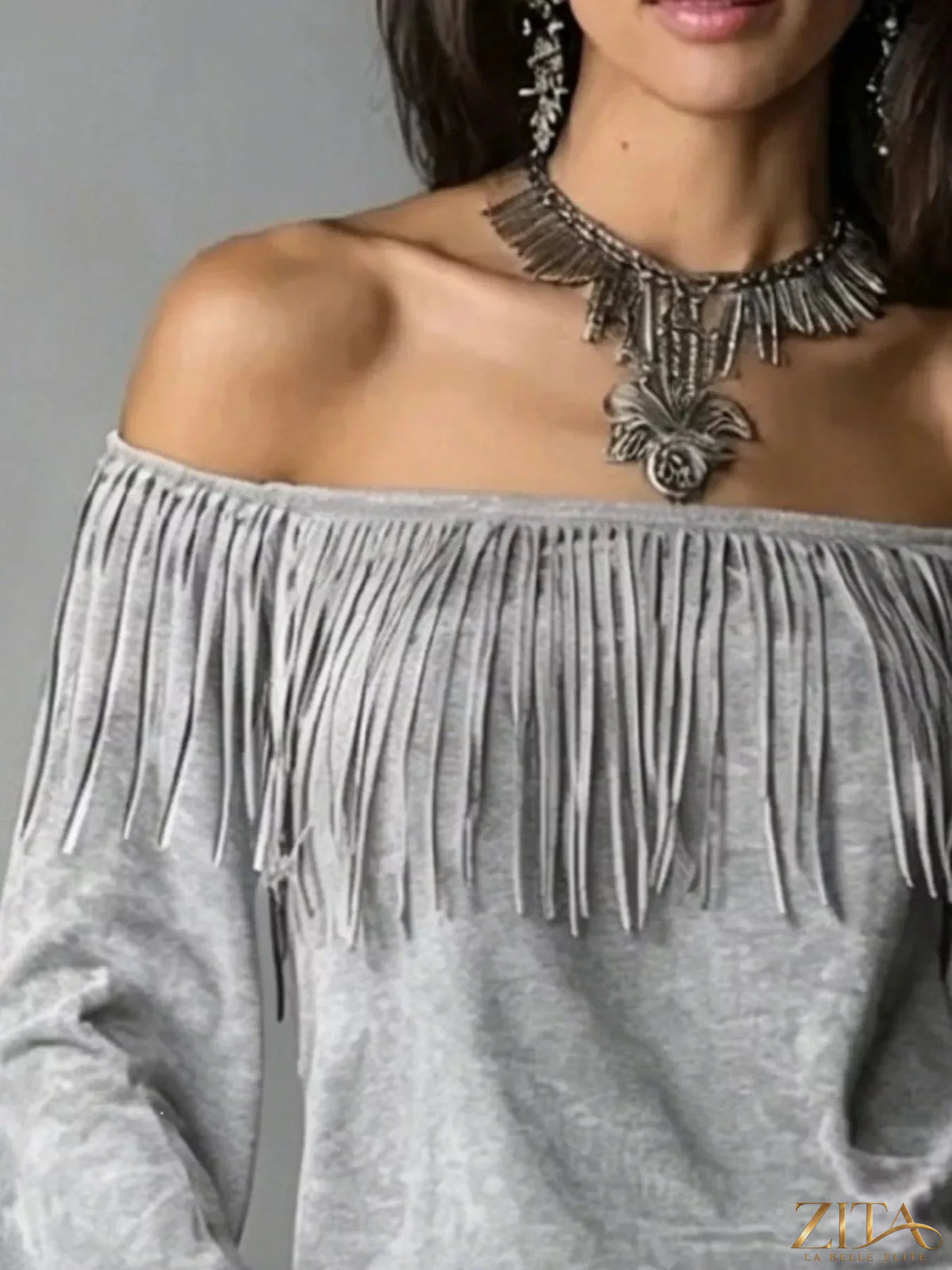 Boho chic off-shoulder suede top with fringed details by Zita La Belle Elite, showcasing its relaxed fit and trendy design.