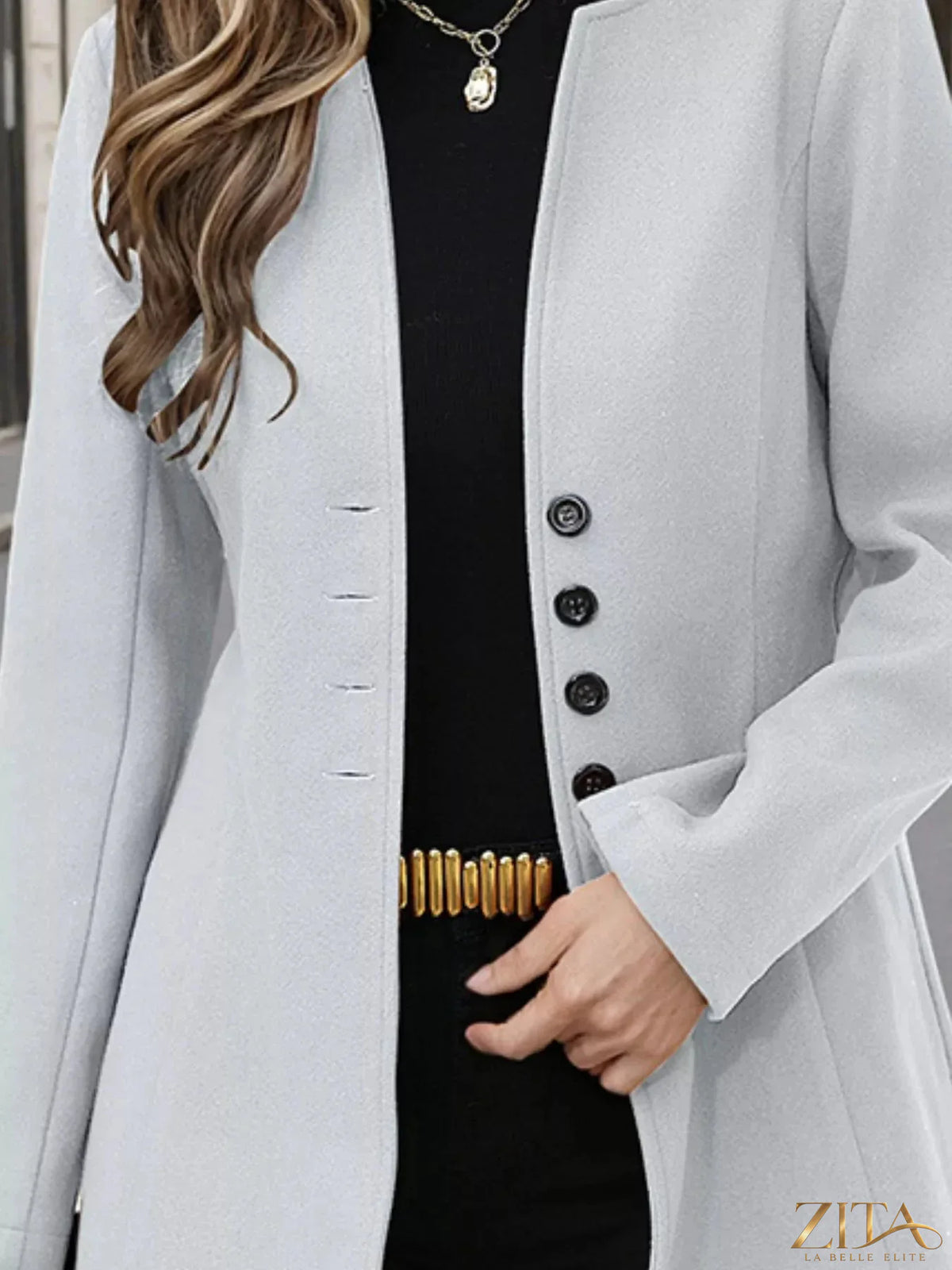 Zita La Belle Elite button-up long sleeve coat in neutral fabric, shown hanging on a wooden hanger.