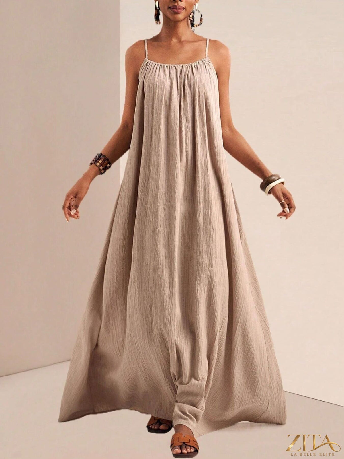 Flowy maxi dress with spaghetti straps in light fabric, by Zita La Belle Elite, shown hanging against a neutral background.