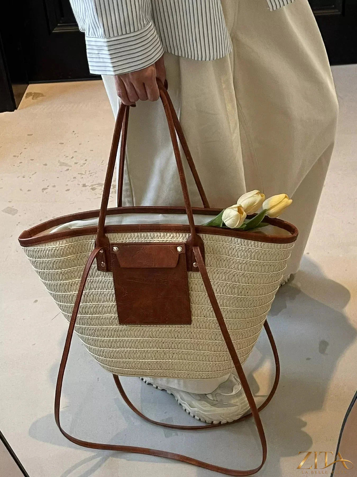 Woven straw tote bag by Zita La Belle Elite with leather handles and spacious interior for casual summer use.