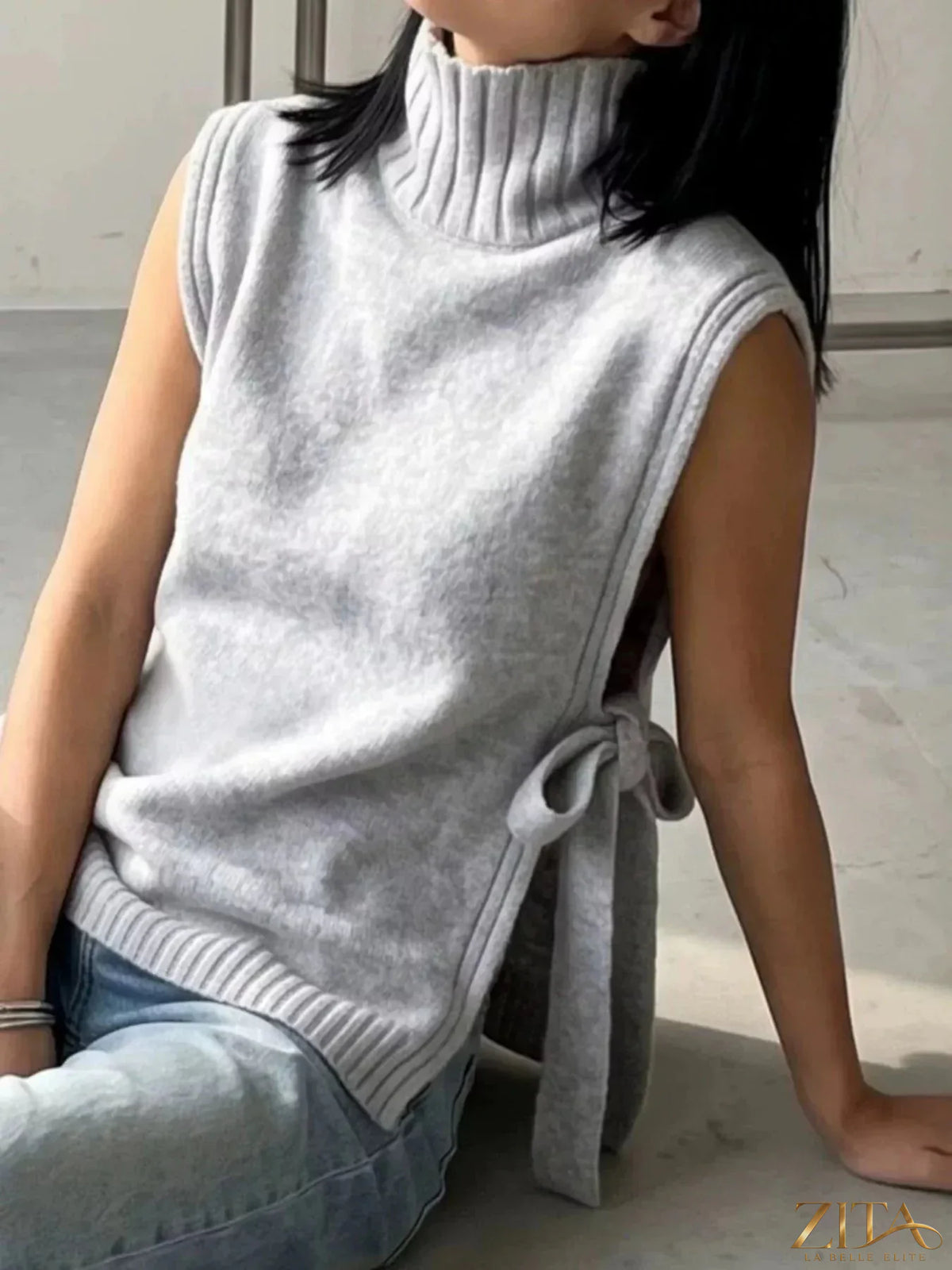Cream-colored turtleneck knit sweater vest with side tie detail, stylish and cozy, from Trendsi.