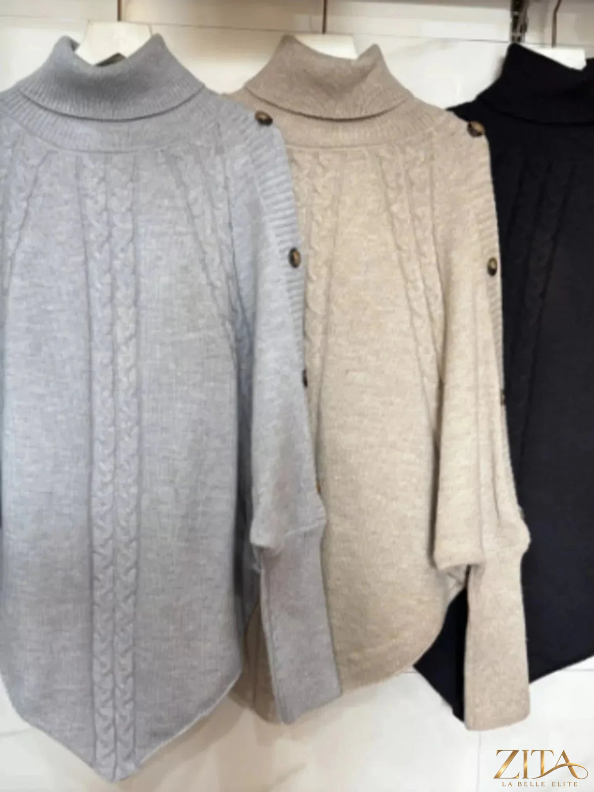 Cable knit turtleneck cape sweater by Trendsi, featuring a cozy, textured design and relaxed fit in a stylish, versatile look.