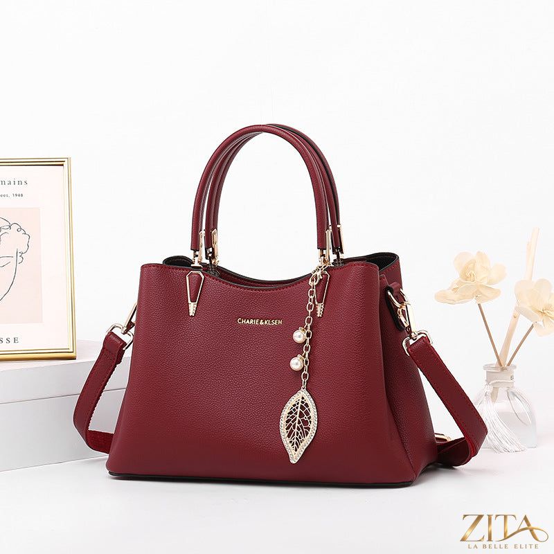 Zita La Belle Elite top-handle leather handbag with structured design and gold-tone hardware on a neutral background.