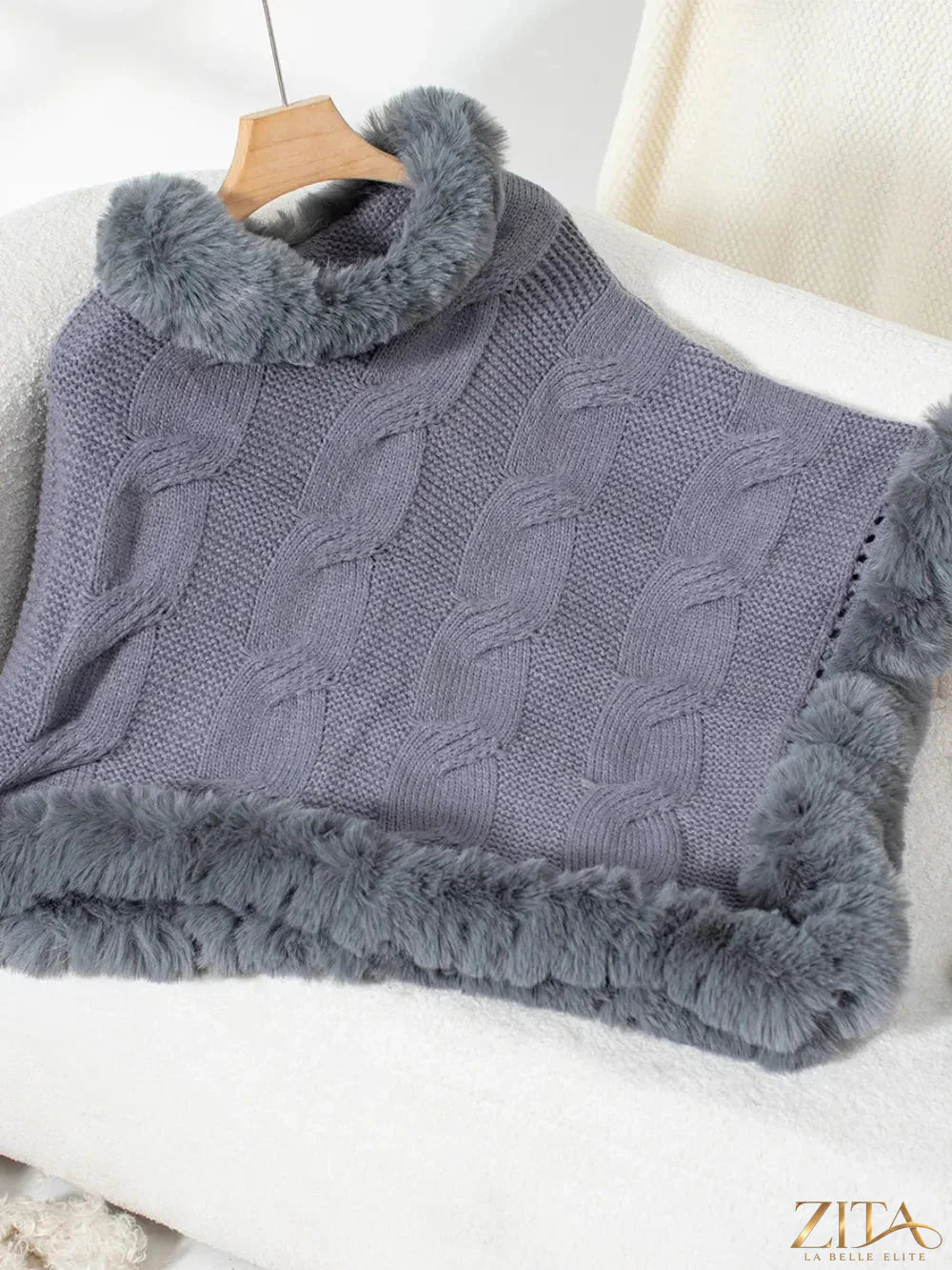 Fuzzy hem cable-knit poncho by Trendsi featuring a cozy, textured knit design with a relaxed fit and stylish draping.