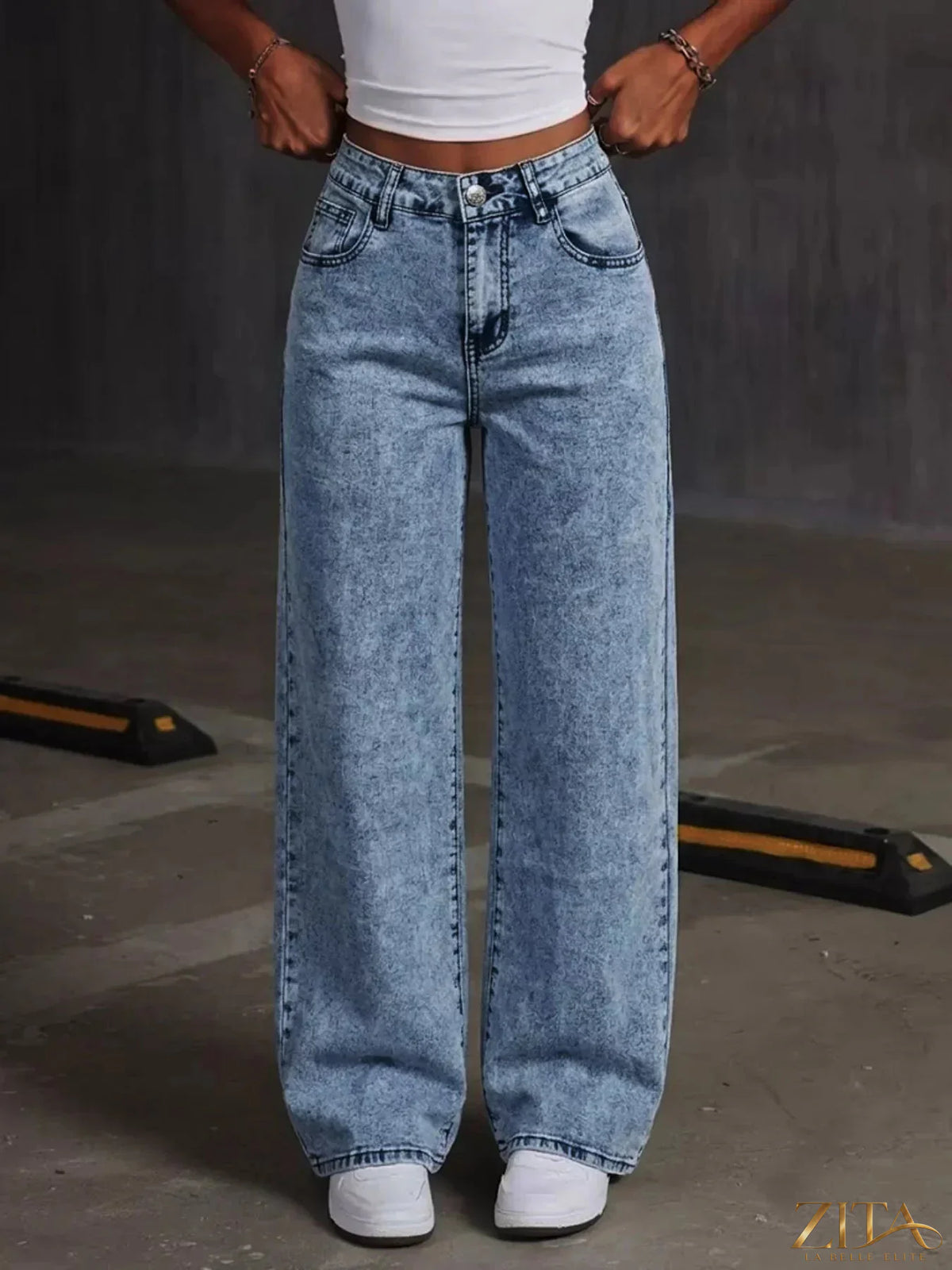 Washed wide leg jeans by Zita La Belle Elite featuring embroidered bow detail on the waistband, denim fabric and relaxed fit.