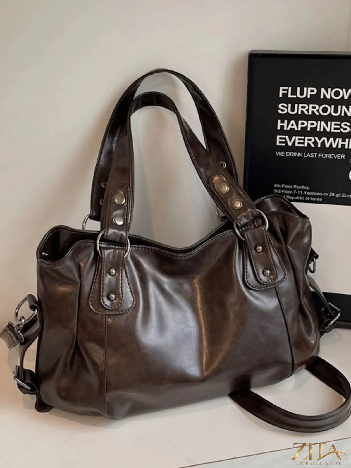 Vintage style leather handbag by Trendsi with a structured design, top handle, and classic brown finish.