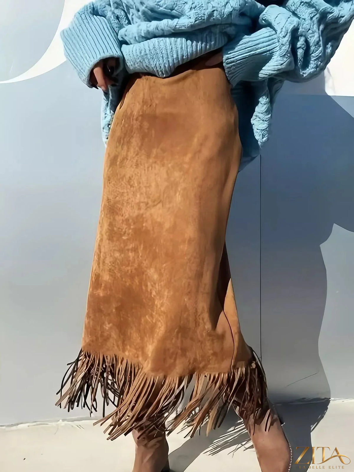 High-waisted suede fringe midi skirt by Trendsi, featuring a flowing silhouette with layered fringe details and a stylish design.