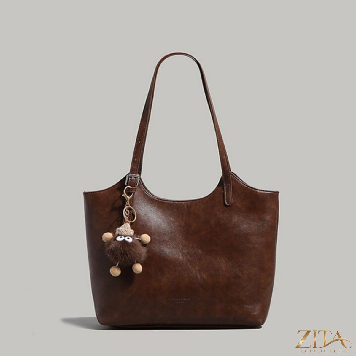 Leather tote bag with charm from Zita La Belle Elite, showcasing spacious interior and stylish design in a natural setting.