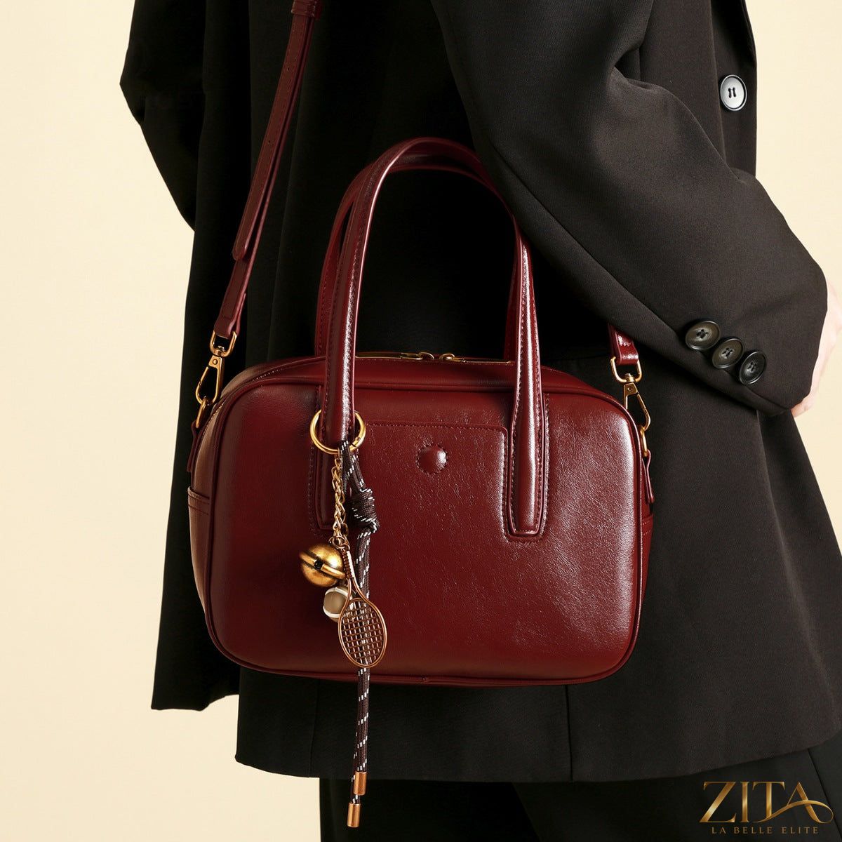 Zita La Belle Elite leather top handle handbag with structured design and gold-tone hardware on a neutral background.