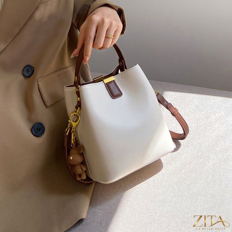Leather bucket crossbody bag from Trendsi with adjustable strap and spacious interior, showcasing soft brown leather and stylish design.