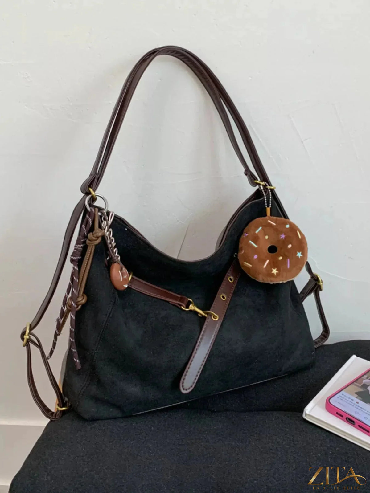 Zita La Belle Elite adjustable strap handbag with decorative charm, black leather with gold-tone hardware, and top handle.