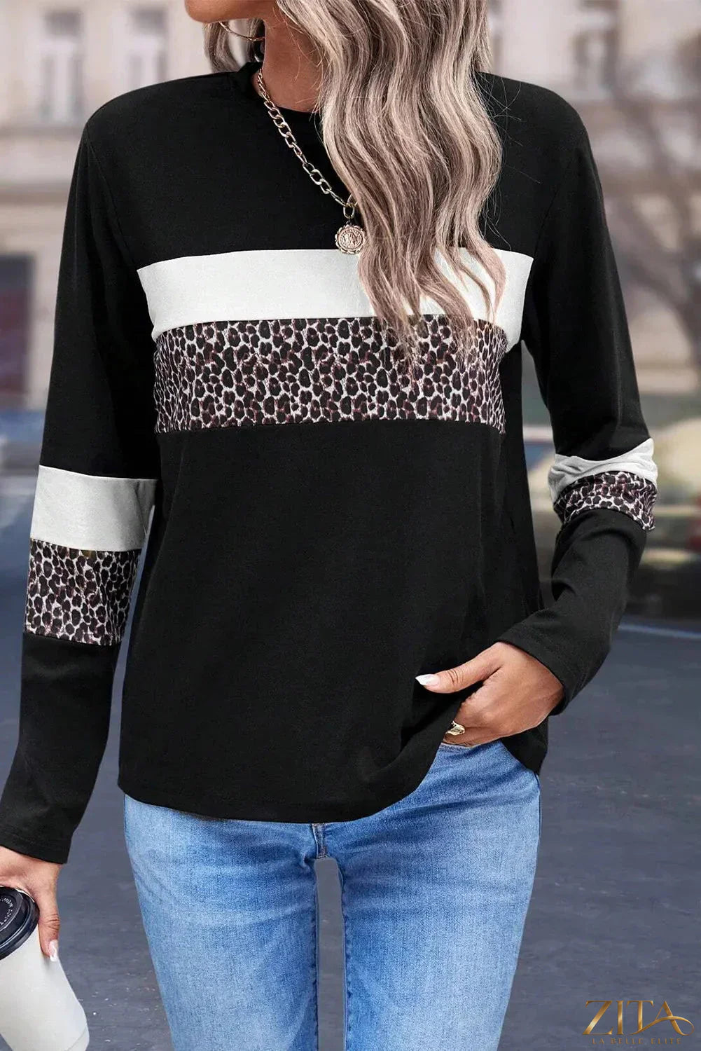 Zita La Belle Elite leopard print round neck long sleeve blouse displayed on a hanger, showcasing stylish animal print design.