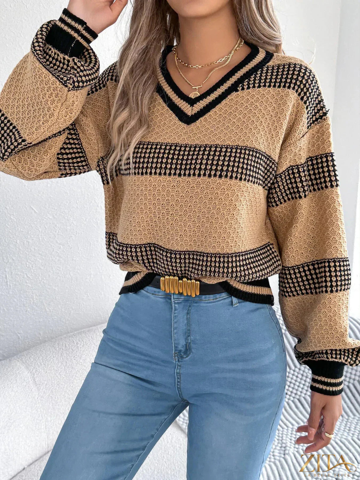 Contrast striped V-neck sweater by Trendsi, showcasing a cozy knit with bold black and white stripes and a classic V-neck design.