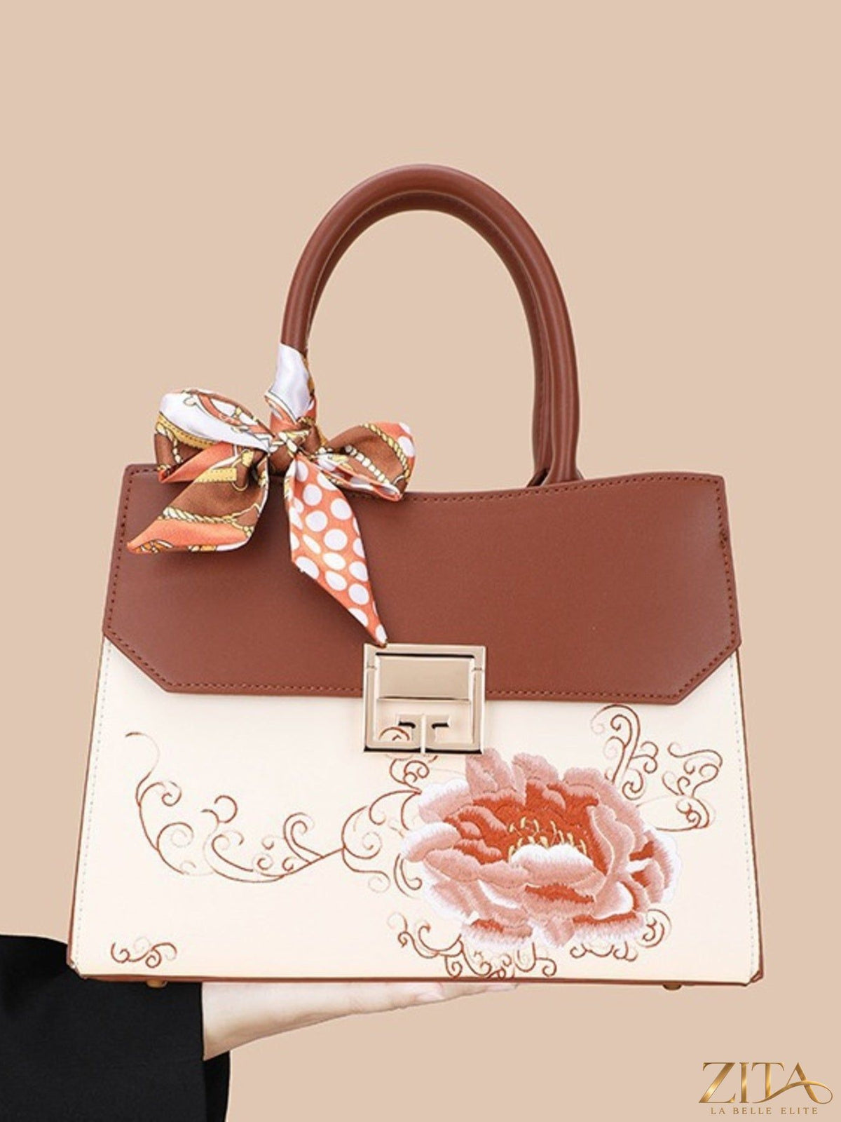 Zita La Belle Elite floral top handle handbag with colorful flower patterns and structured design on a white background.