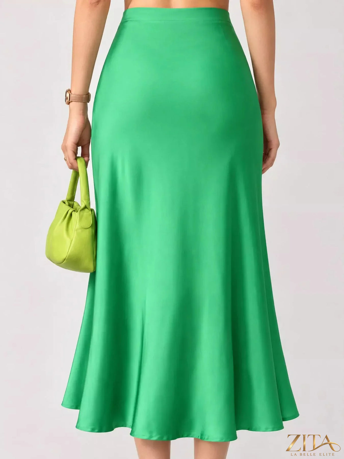 High-waisted satin midi skirt in smooth, shiny fabric with a flattering fit, styled on a model for a trendy look.