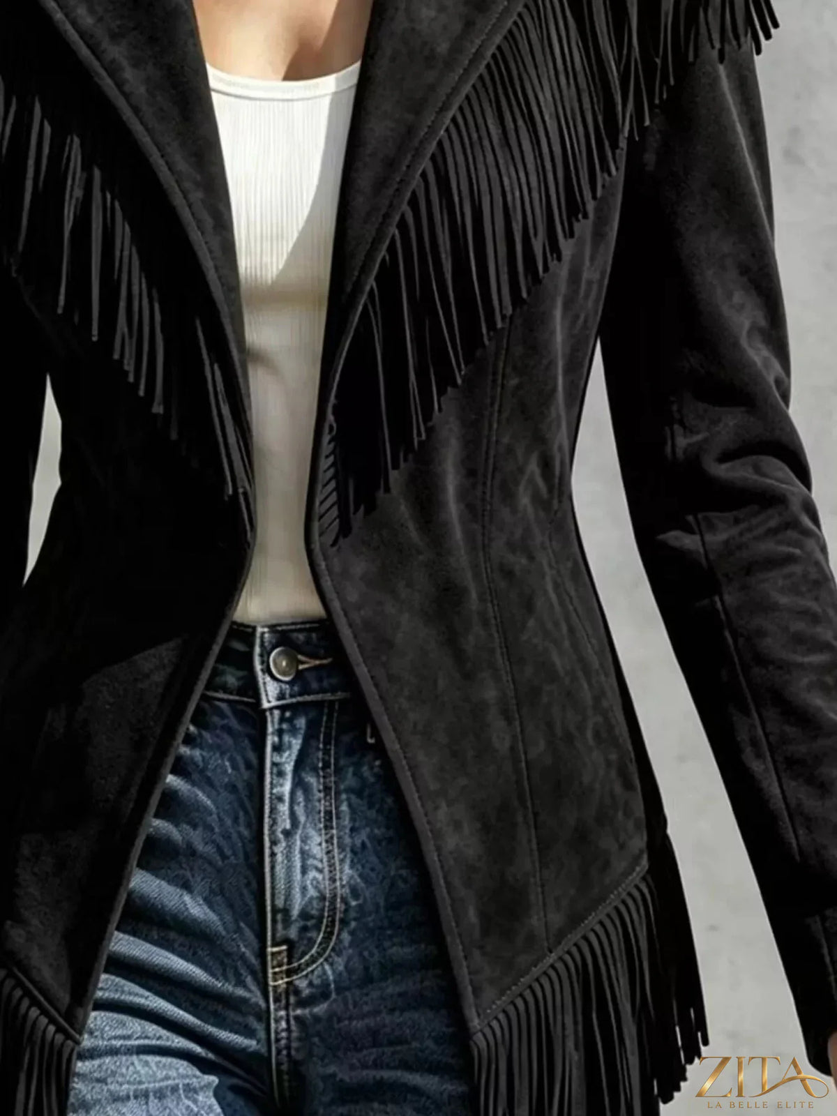 Western-inspired fringed open front jacket by Trendsi, featuring suede-like material and fringe detailing on the sleeves and hem.
