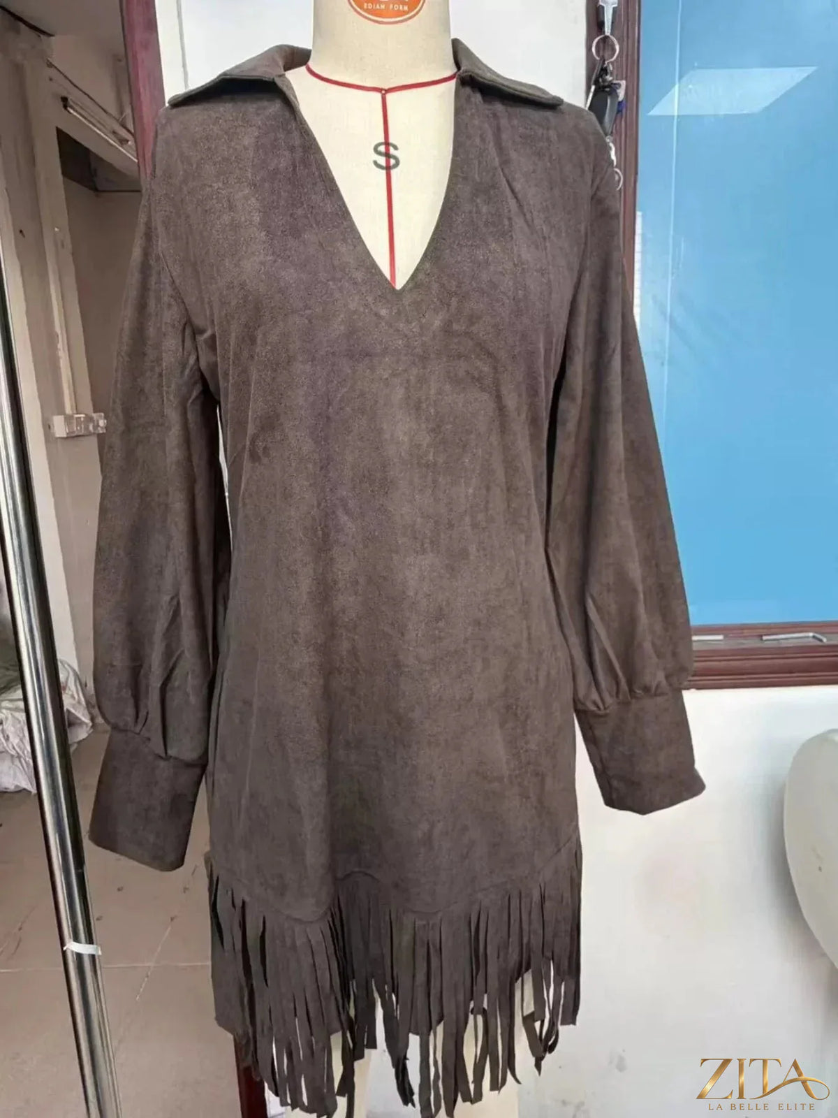 Fringed lantern sleeve dress by Trendsi featuring a flowy design with dramatic lantern sleeves and fringe details.