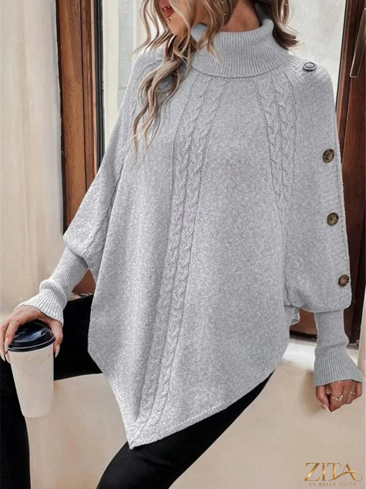 Cable knit turtleneck cape sweater by Trendsi, showcasing a cozy, textured knit design with a high turtleneck and cape-style silhouette.