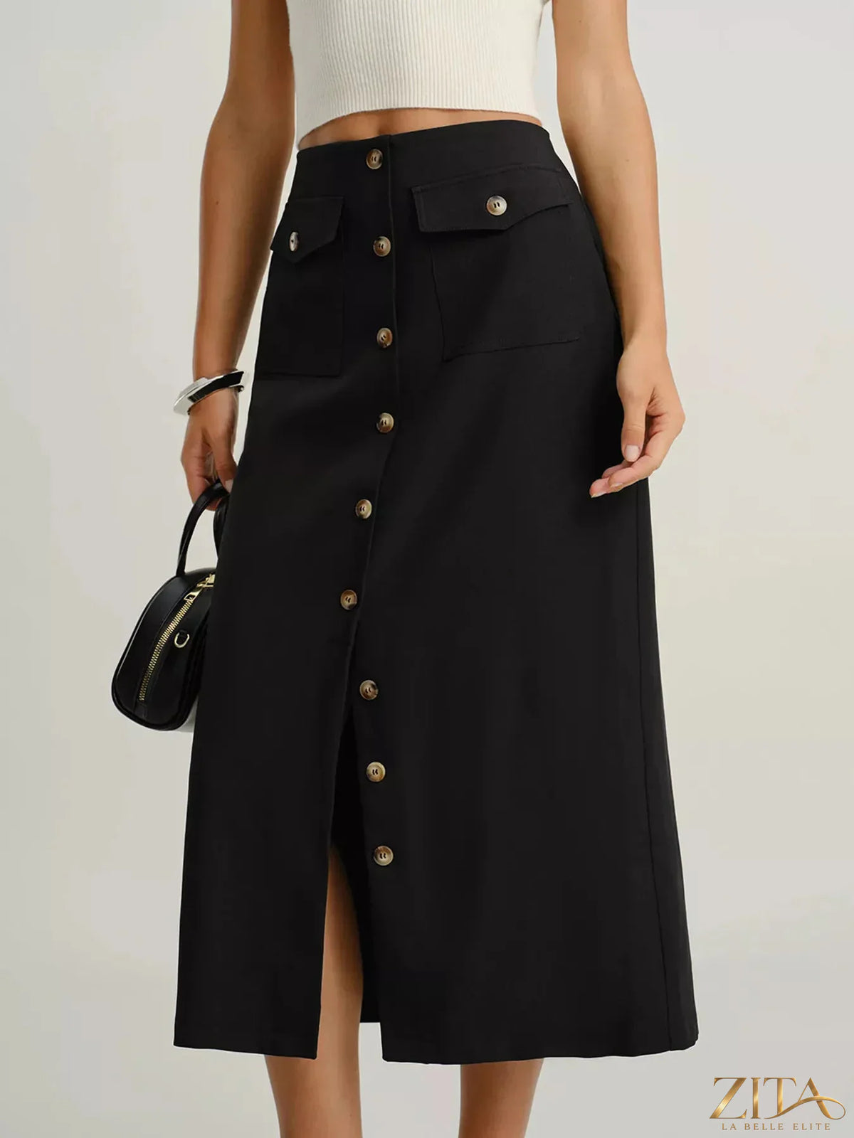 Button-front pocketed midi skirt from Trendsi featuring a stylish design with functional pockets and flowing fabric.