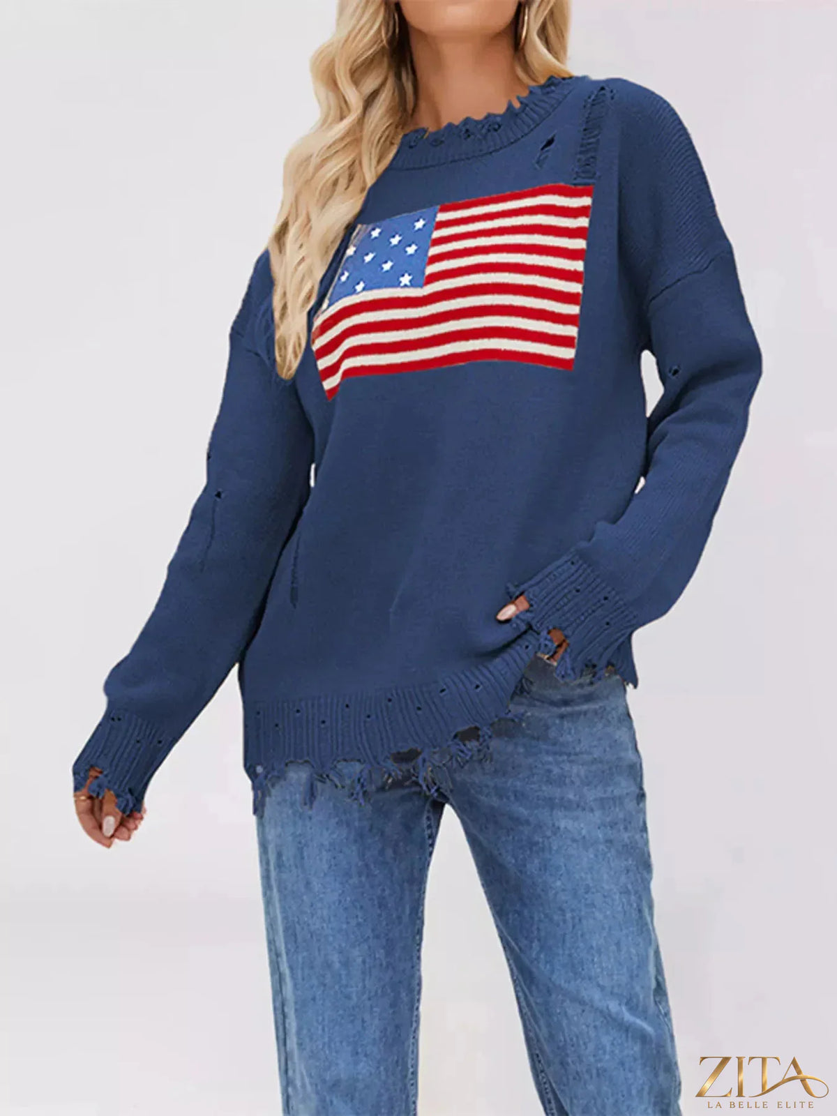 Distressed American flag graphic sweater with long sleeves and cozy knit, featuring bold red, white, and blue colors.