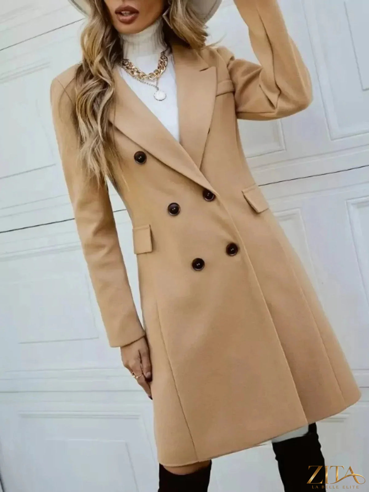 Zita La Belle Elite double-breasted longline coat in neutral fabric, shown hanging on a wooden hanger.