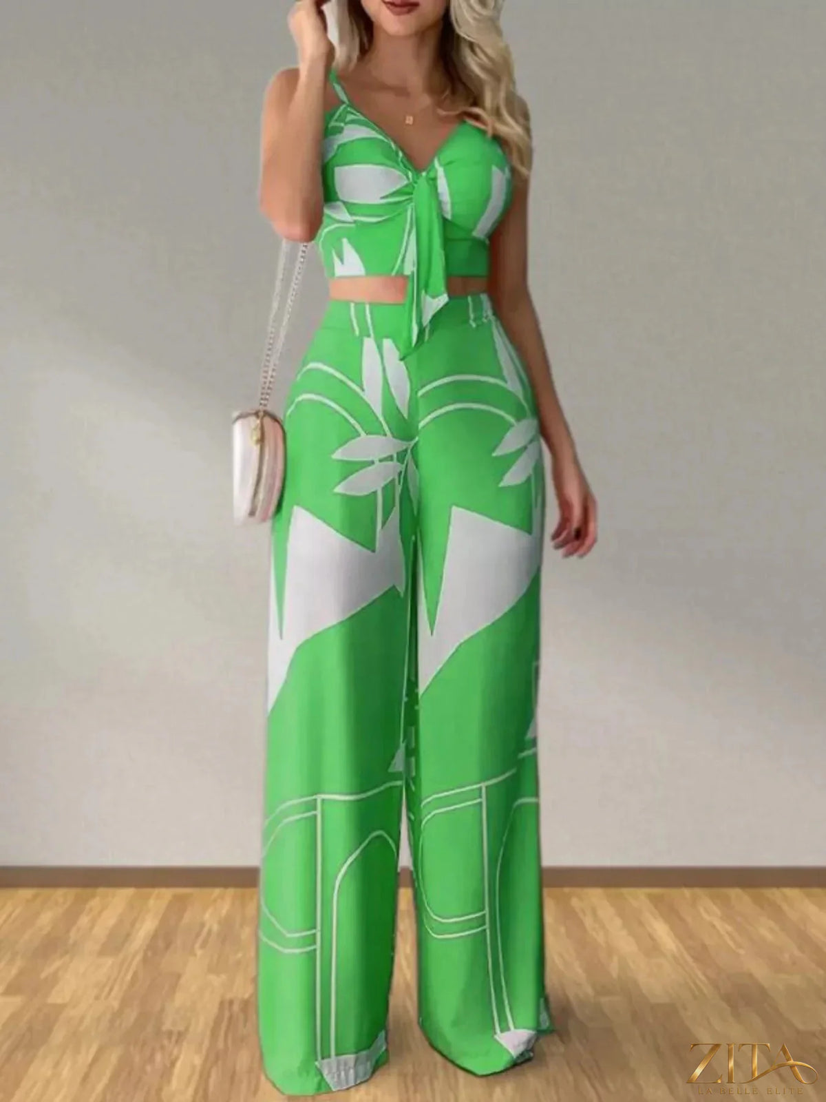 Tropical print spaghetti strap crop top and wide-leg pants set by Zita La Belle Elite, featuring vibrant floral design and lightweight fabric.