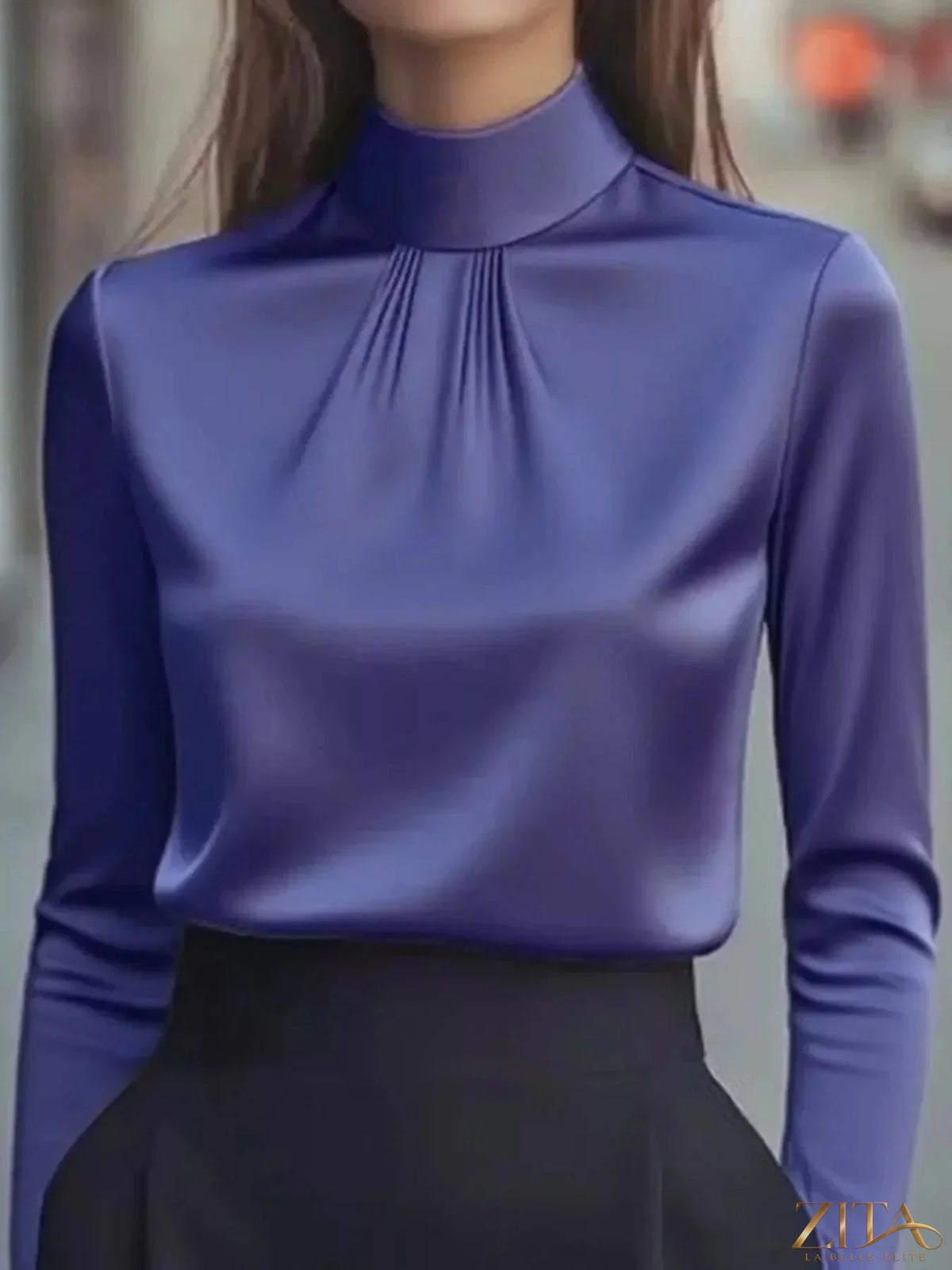 Zita La Belle Elite mock neck long sleeve blouse with pleated detail, shown in black on a model.