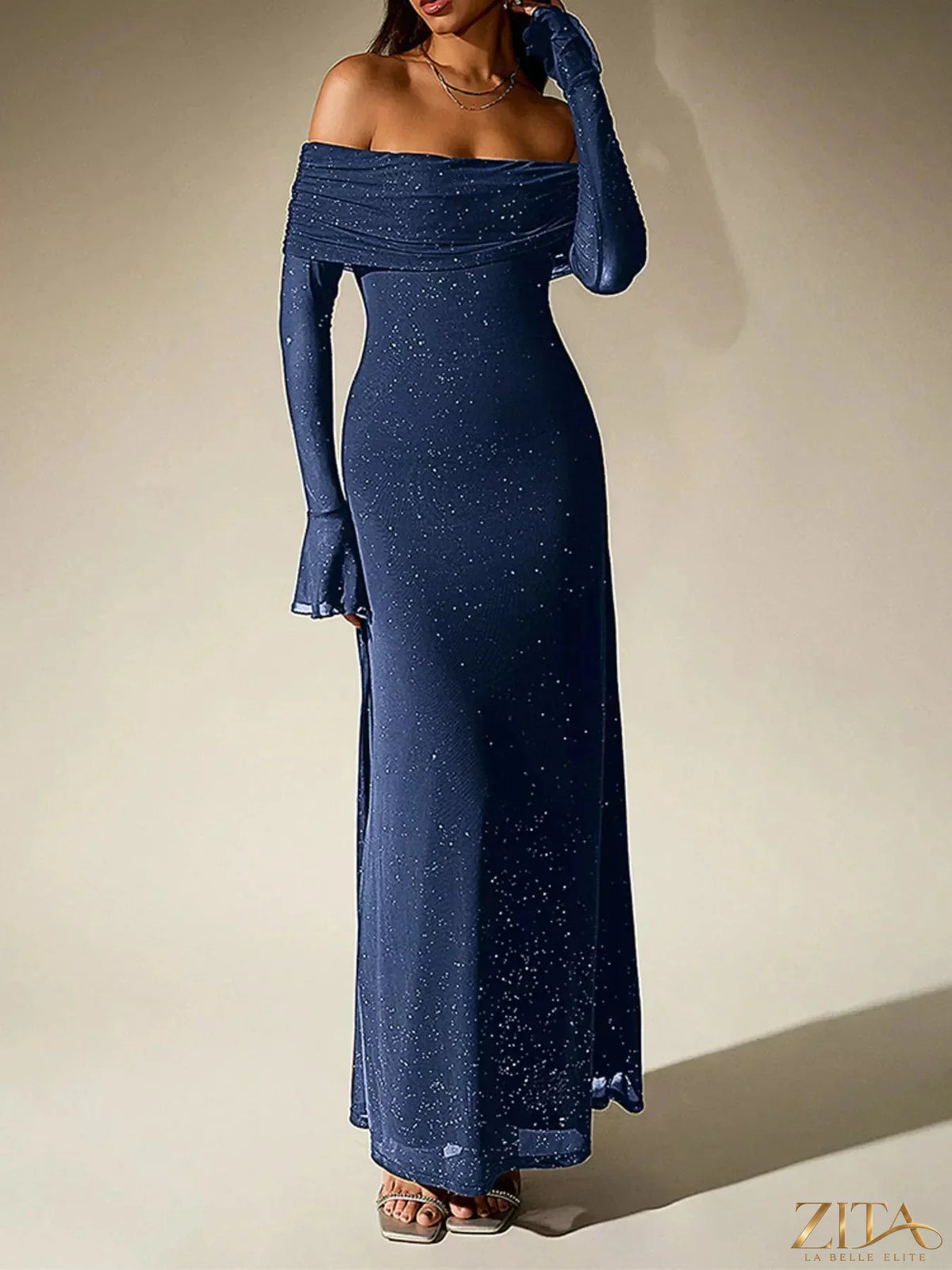 Zita La Belle Elite glitter off-shoulder maxi dress with flowing fabric and sparkling details, suitable for formal occasions.