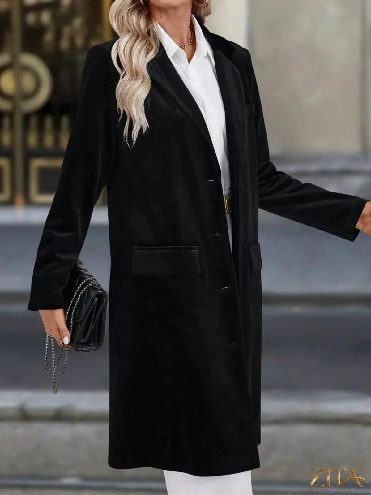 Zita La Belle Elite longline coat with lapel collar, long sleeves, and tailored fit, shown on a model in a stylish outdoor setting.