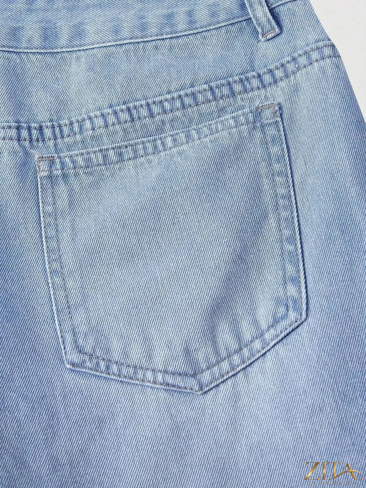 Zita La Belle Elite asymmetric raw hem wide-leg jeans displayed on a model, showcasing distressed details and relaxed fit.