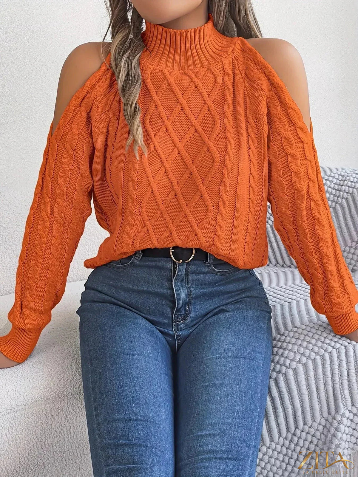 Cold-shoulder cable knit sweater by Trendsi featuring a cozy design with cut-out shoulders and textured knit pattern.