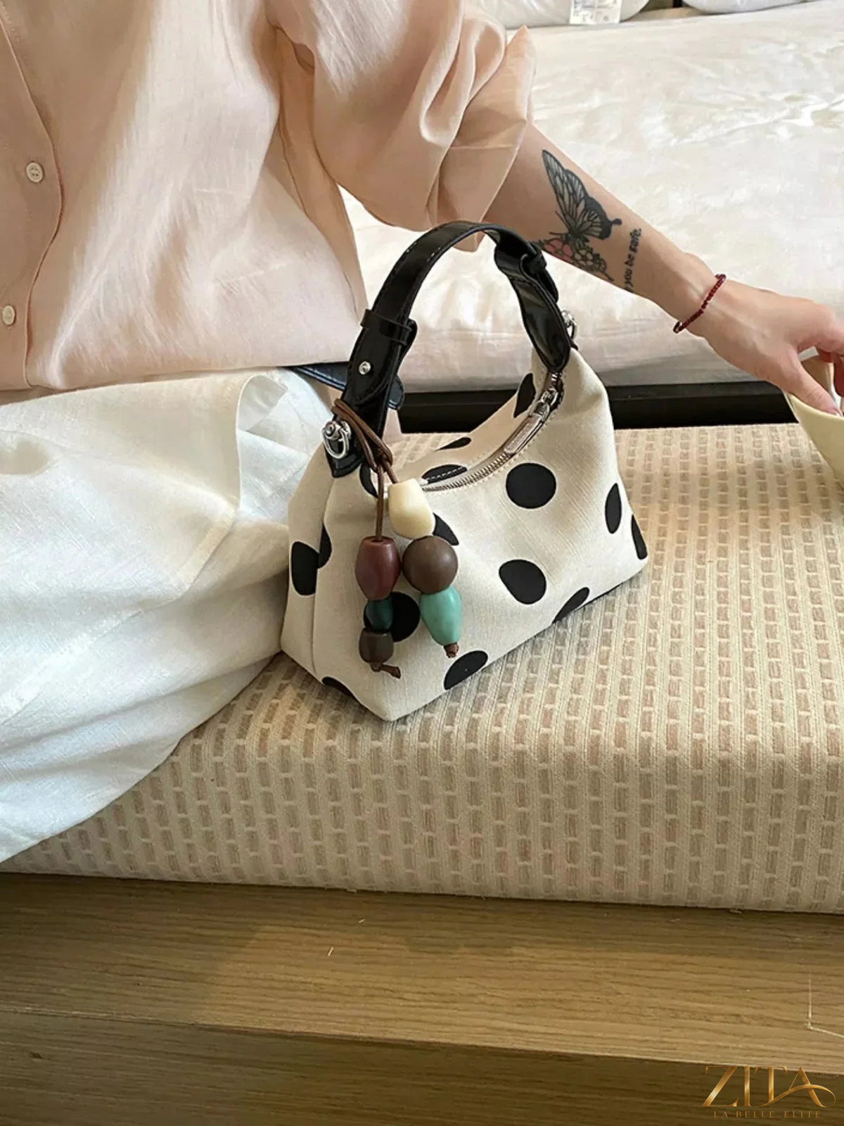 Zita La Belle Elite polka dot PU leather handbag with top handles and gold accents on a plain background