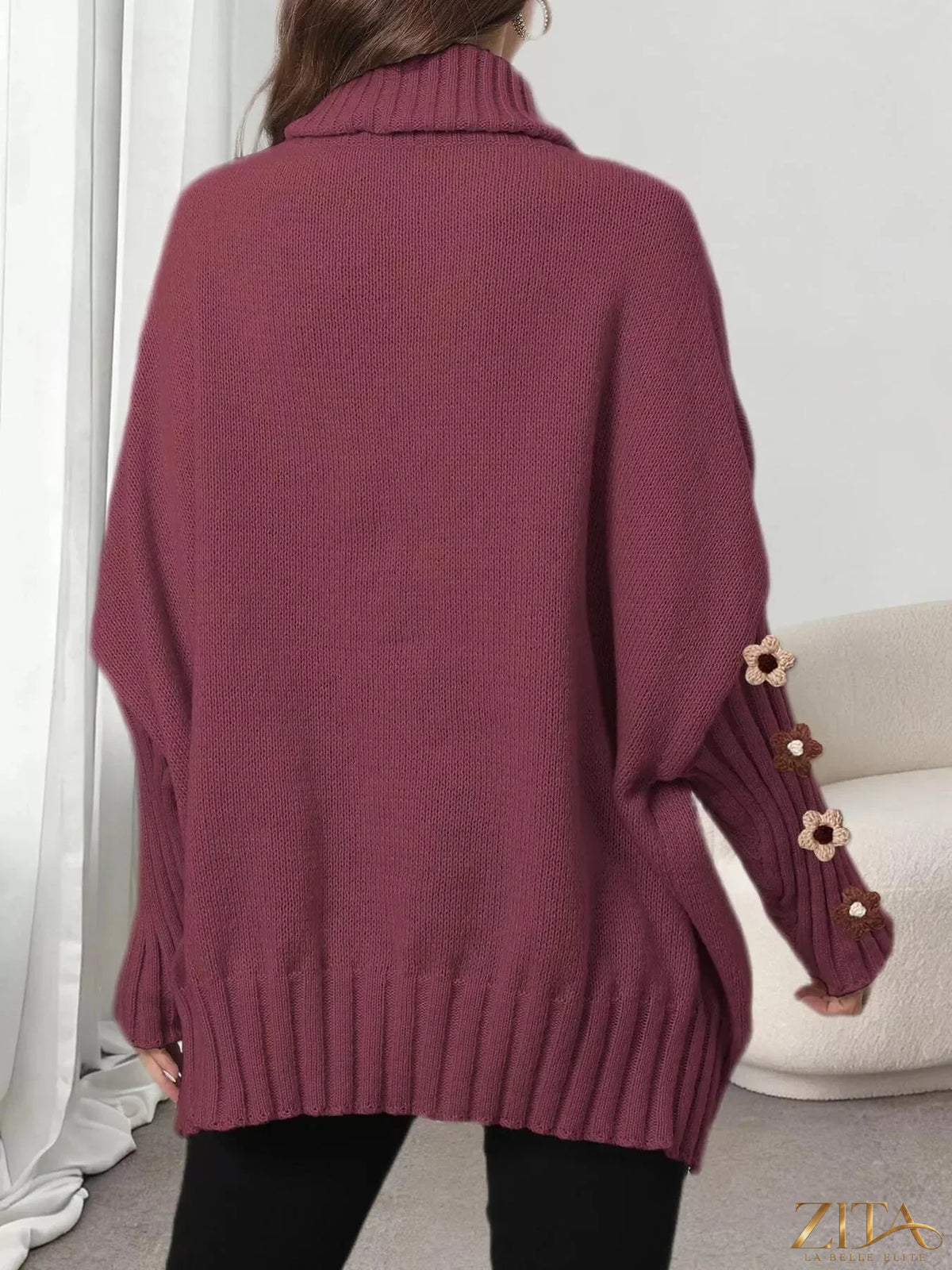 Zita La Belle Elite oversized turtleneck sweater with floral applique sleeves, cozy knit design, in soft neutral tones.
