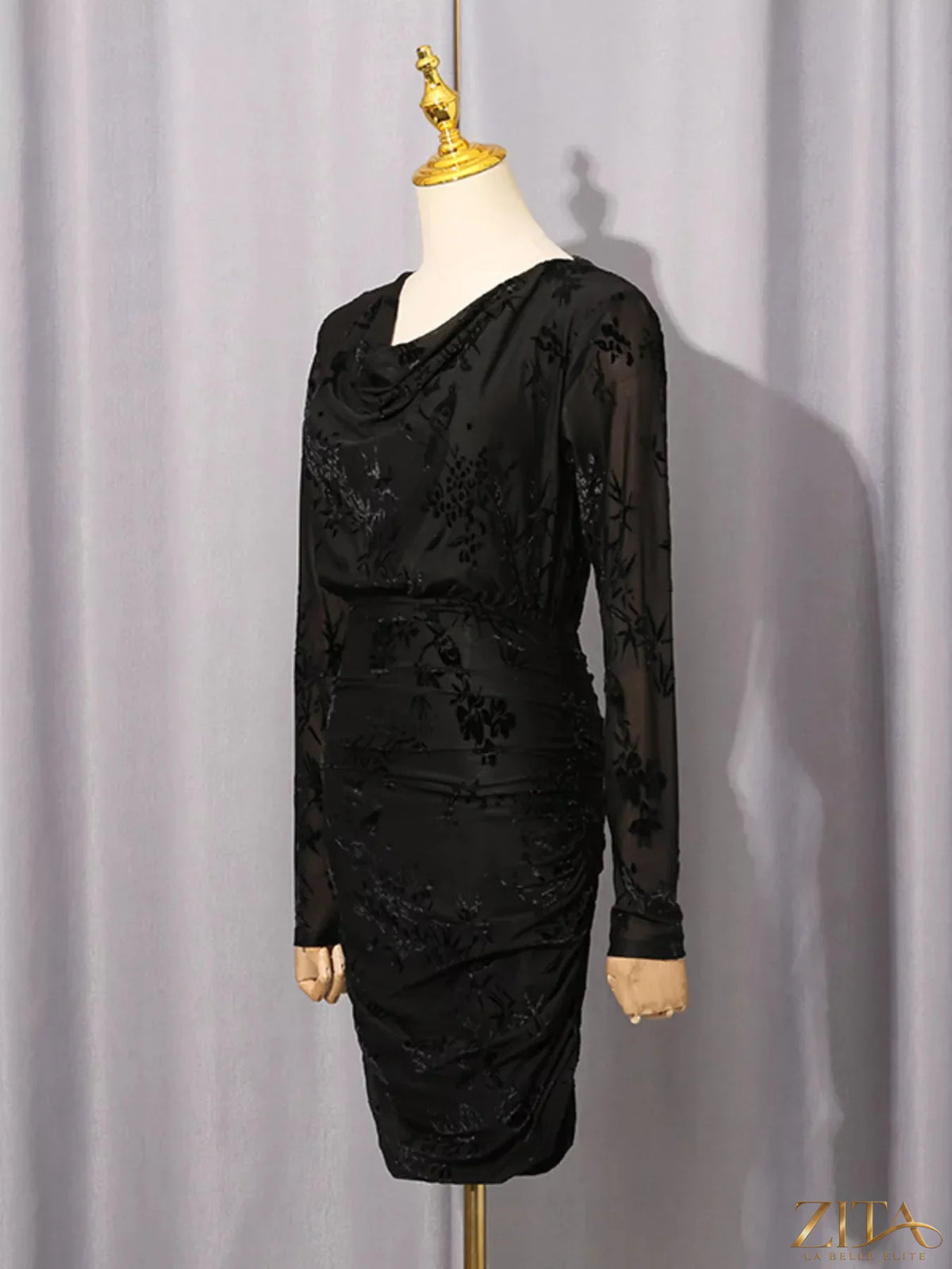 Black ruched long sleeve mini dress from Trendsi, featuring a fitted silhouette and stylish design, shown on a model.