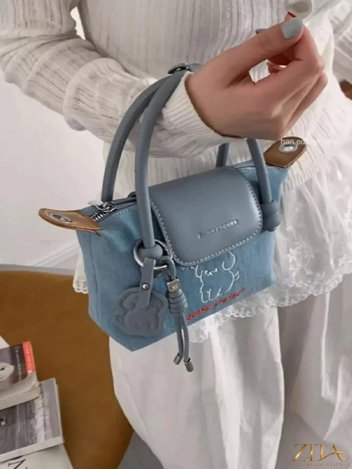 Denim handbag by Zita La Belle Elite featuring embroidered puppy design, stylish accessory with top handle and decorative stitching.
