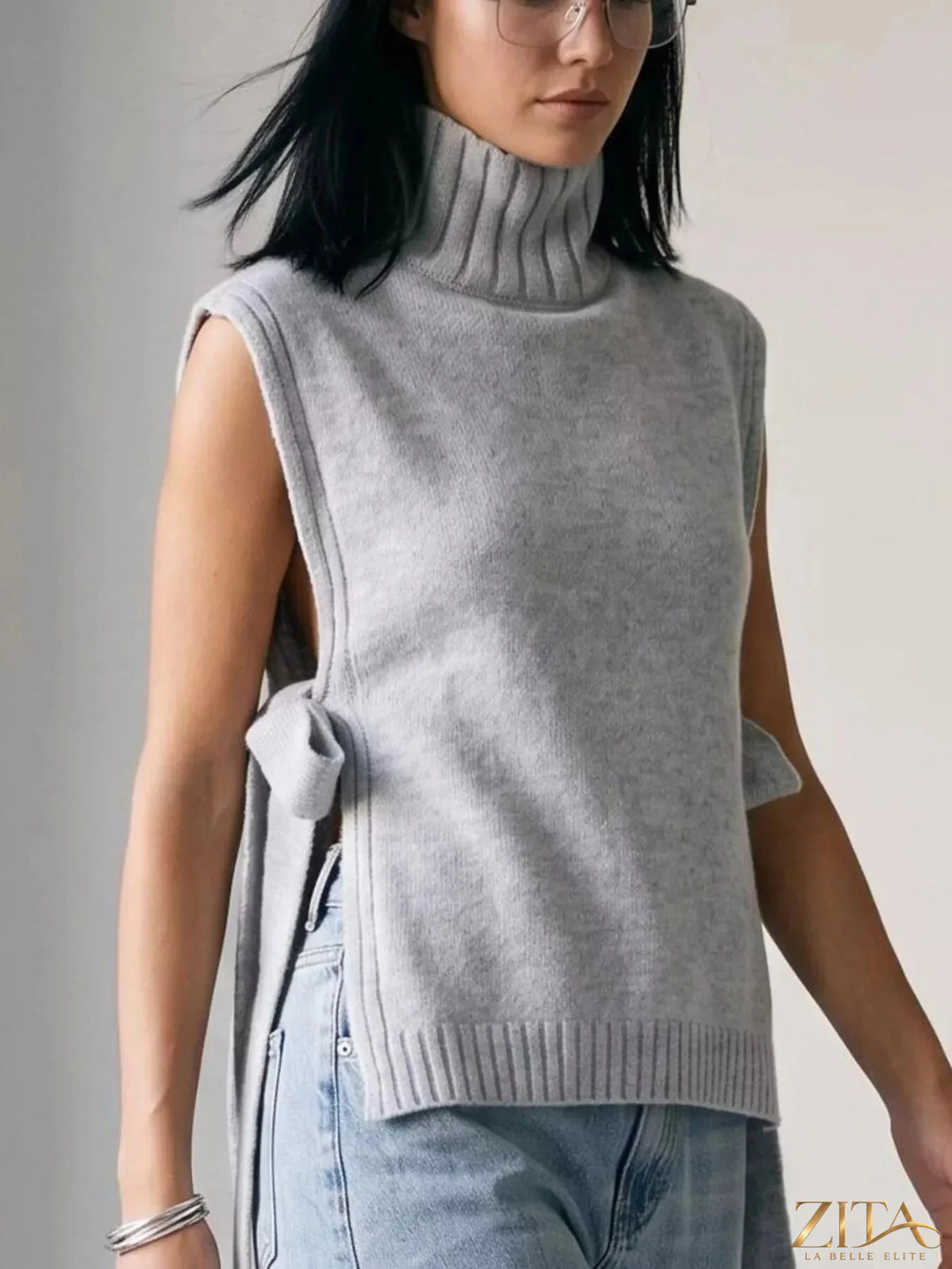 Knit turtleneck sweater vest with side tie detail, Trendsi brand, featuring a cozy, ribbed knit fabric and classic design.
