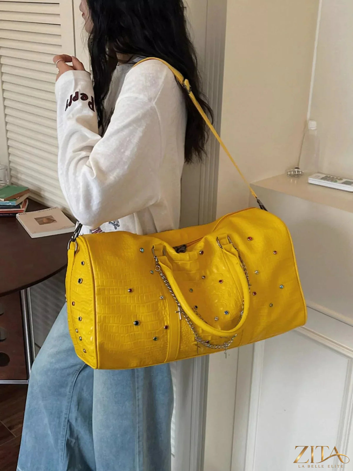 Trendsi studded leather duffel bag with metal details, top handles, and adjustable shoulder strap for travel and everyday use.